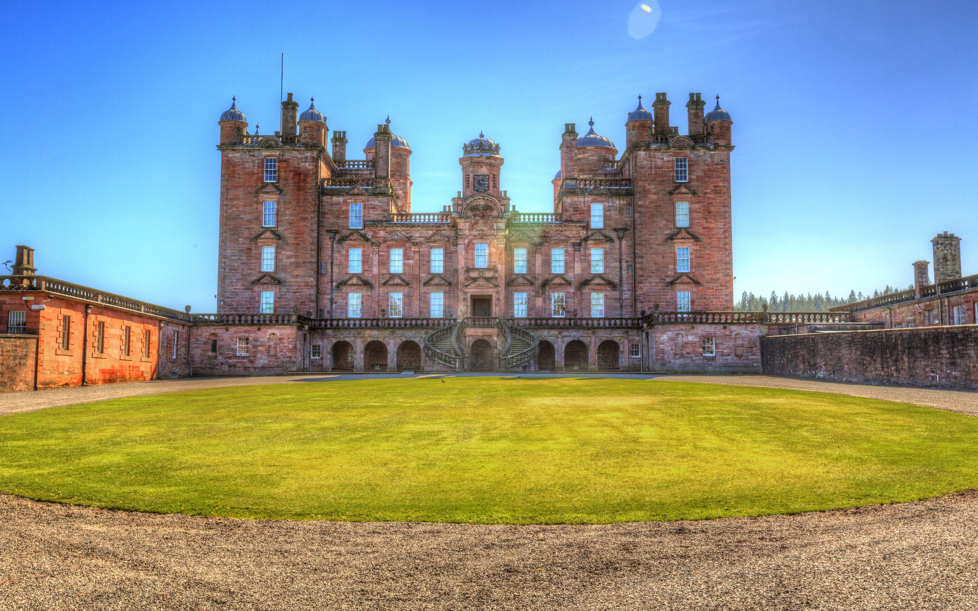 Замок Drumlanrig Castle с зеленым  газоном, Шотландия 