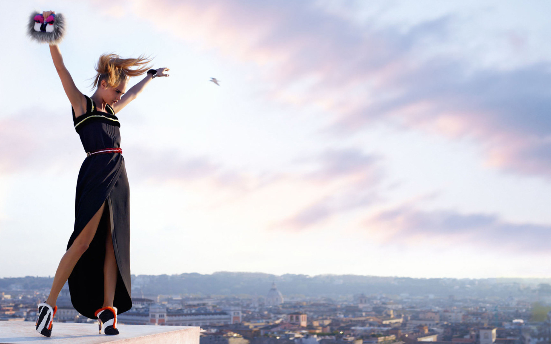 Актриса Кара Делевинь в черном платье на фоне неба 