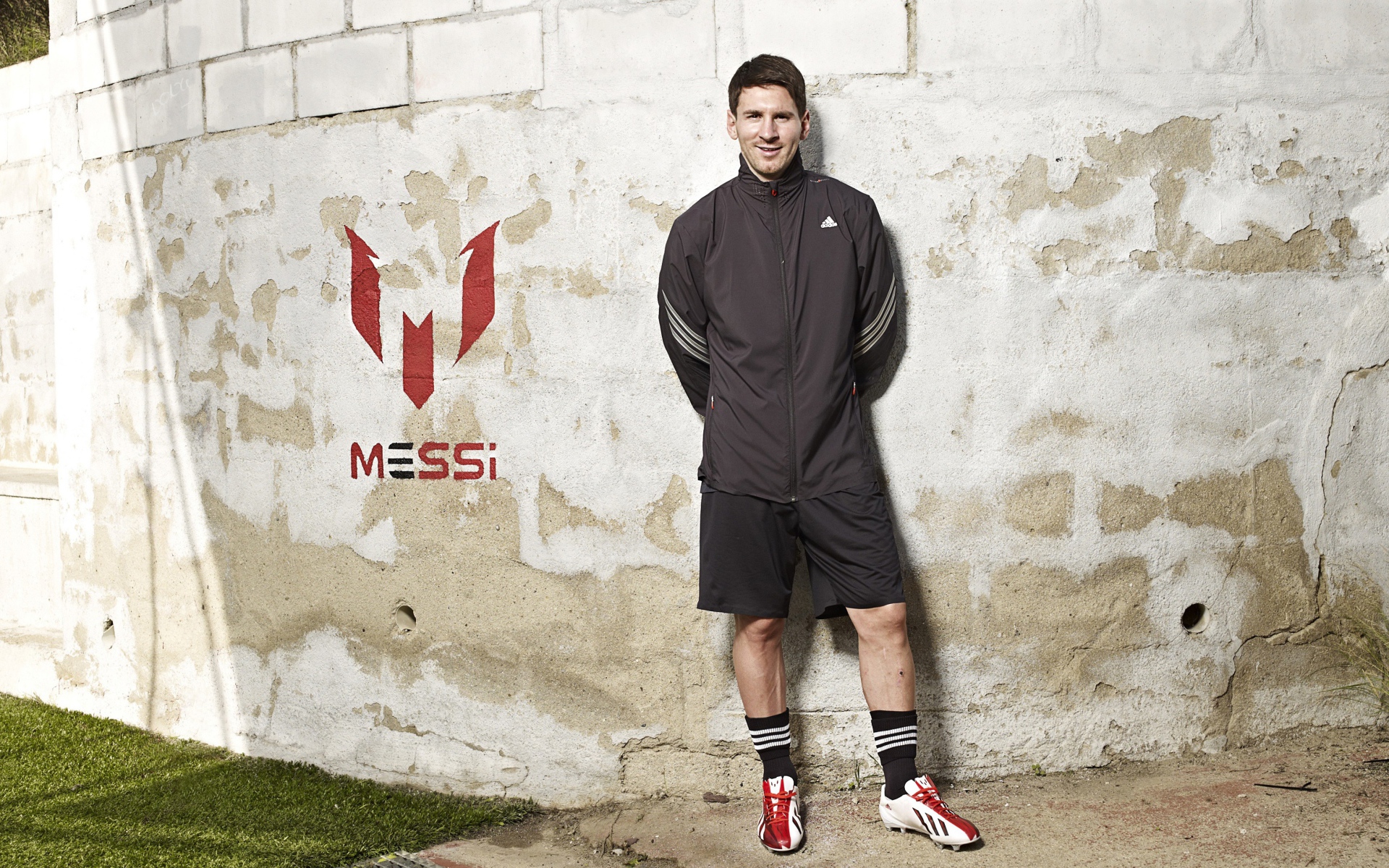 Футболист Лионель Месси позирует  на фоне стены 