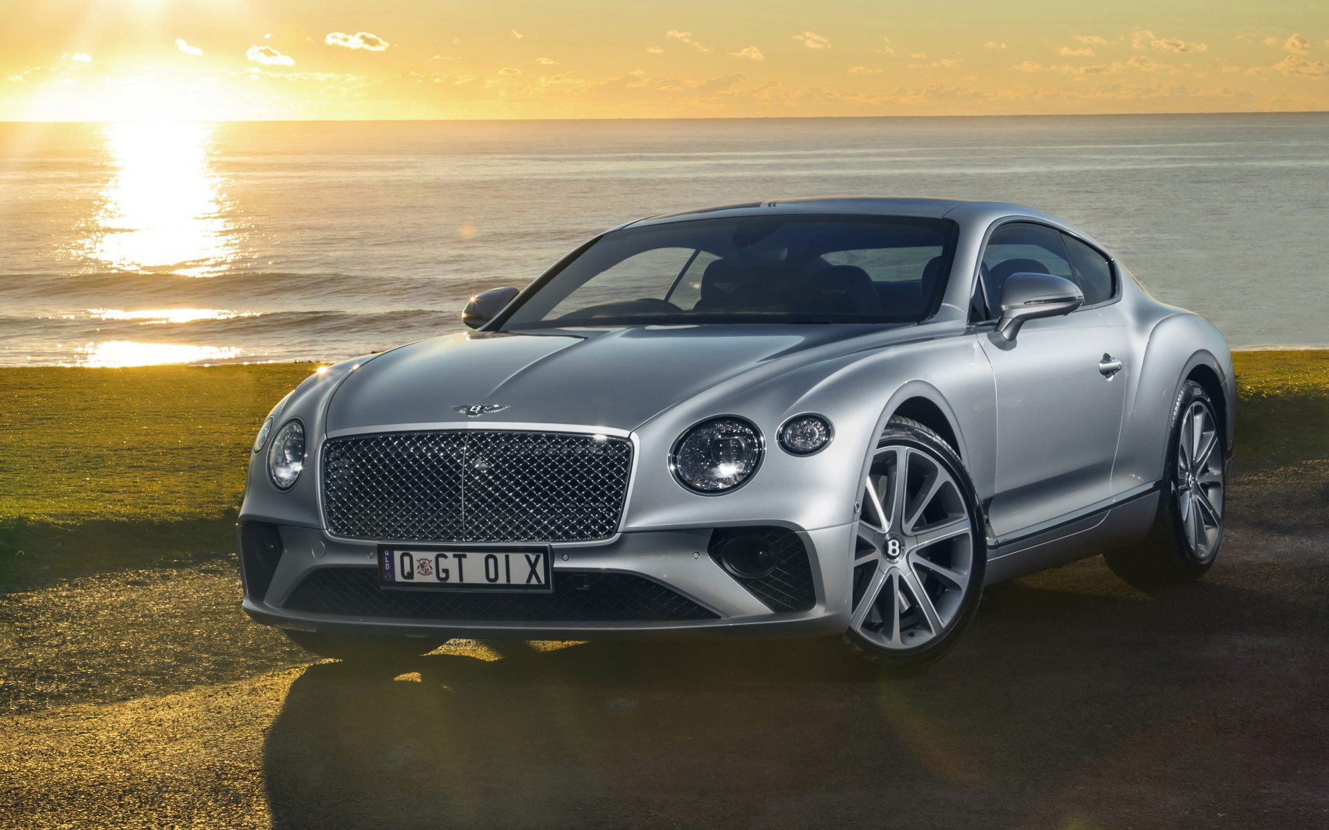 Серебристый Bentley Continental GT 2018 года на фоне моря