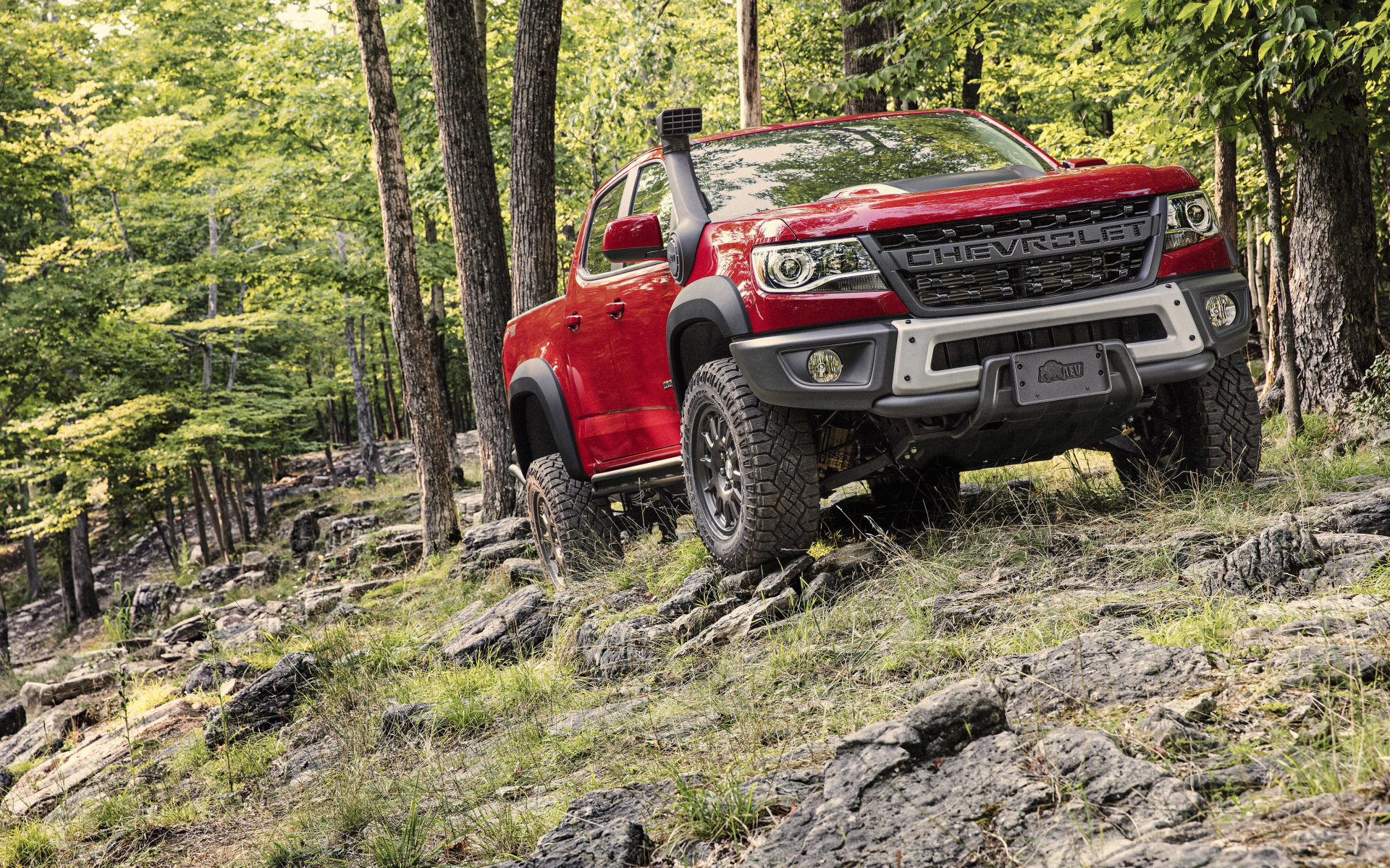 Красный внедорожник Chevrolet Colorado ZR2 Bison, 2019 года в лесу