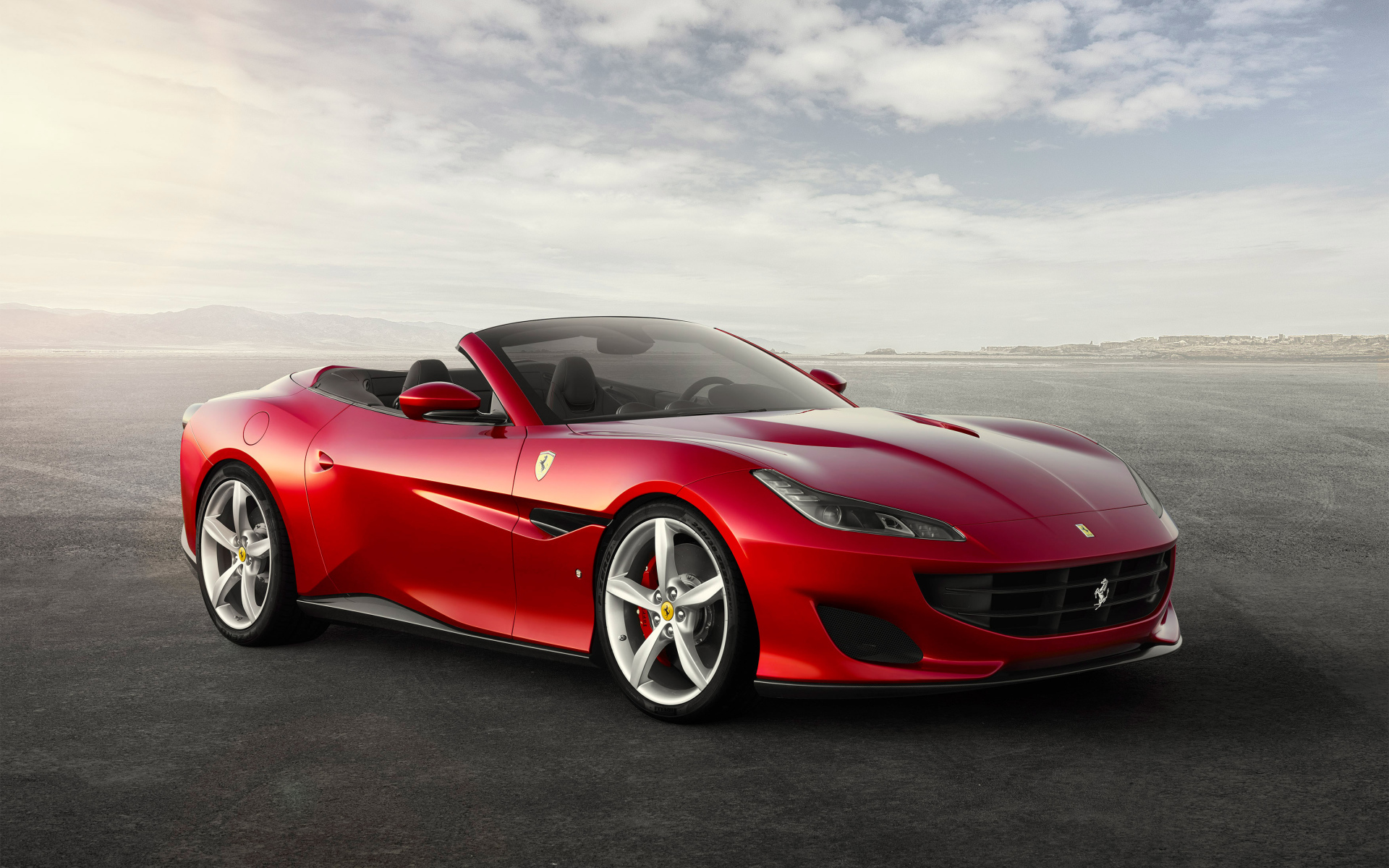Красный автомобиль кабриолет Ferrari Portofino на фоне неба