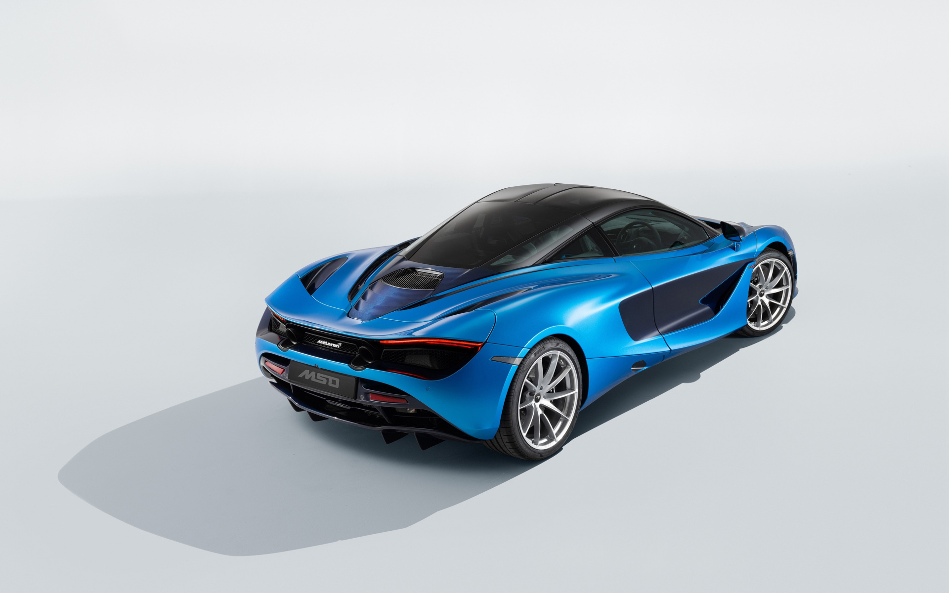 Голубой быстрый автомобиль McLaren 720S, 2018 года вид сзади
