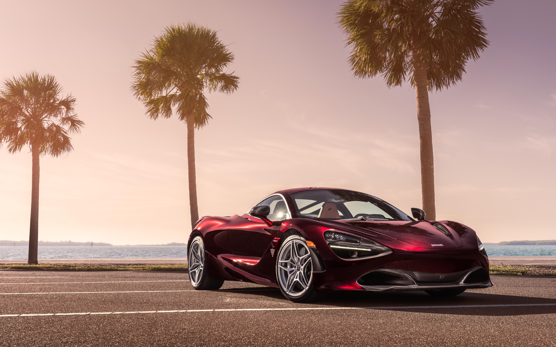 Бордовый спортивный автомобиль McLaren 720S, 2018 на фоне пальм