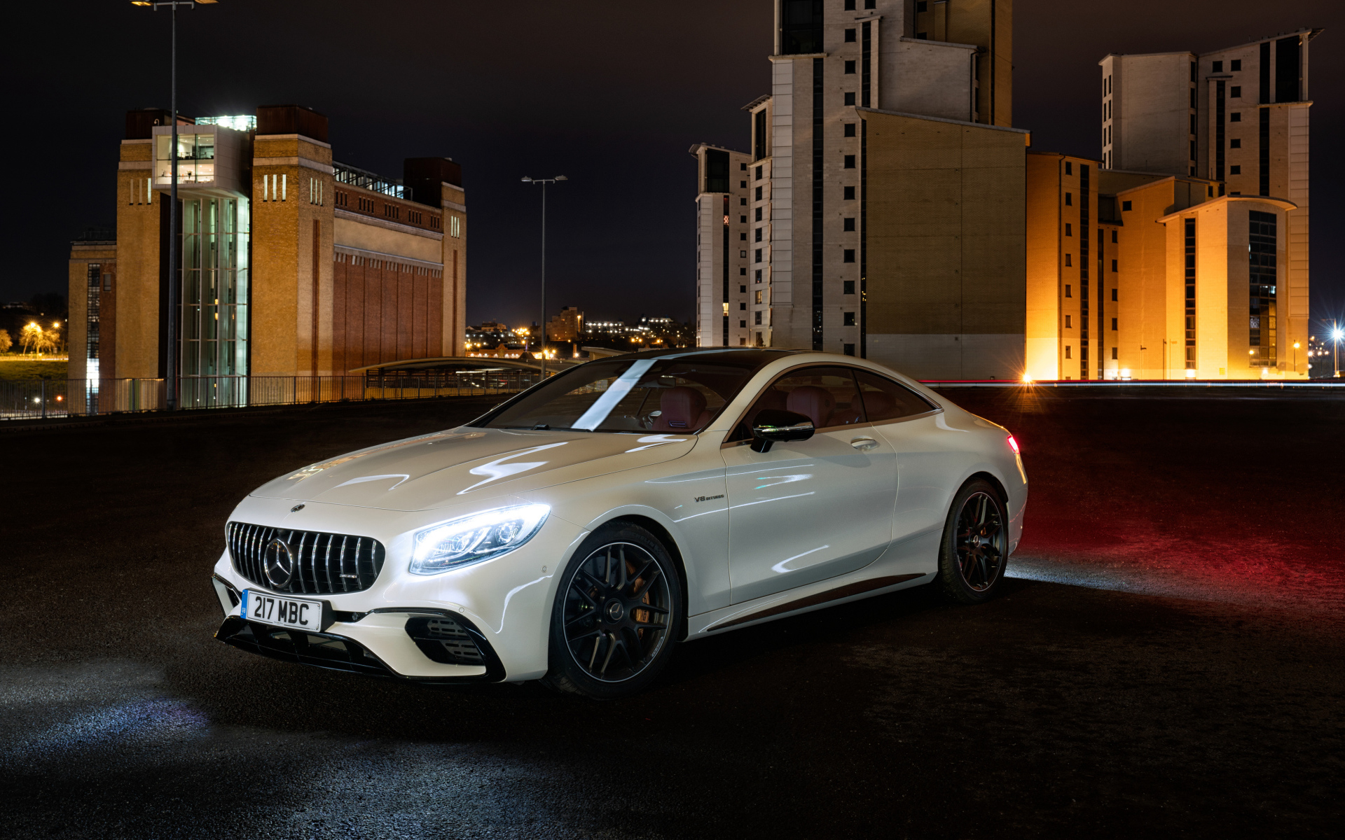 Белый автомобиль Mercedes AMG S 63 4MATIC Coupe, 2018 года на фоне города