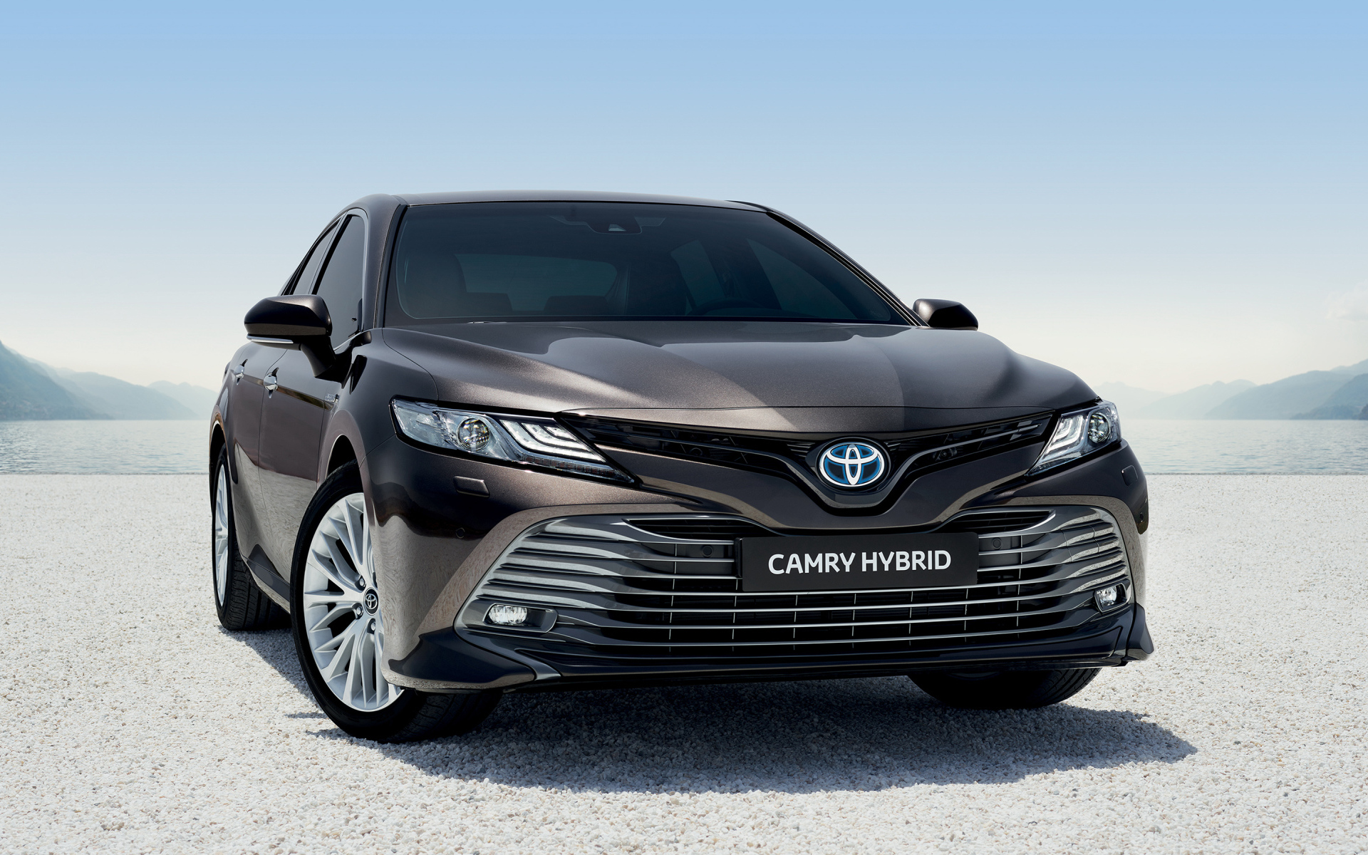 Автомобиль Toyota Camry Hybrid 2019 года стоит на песке