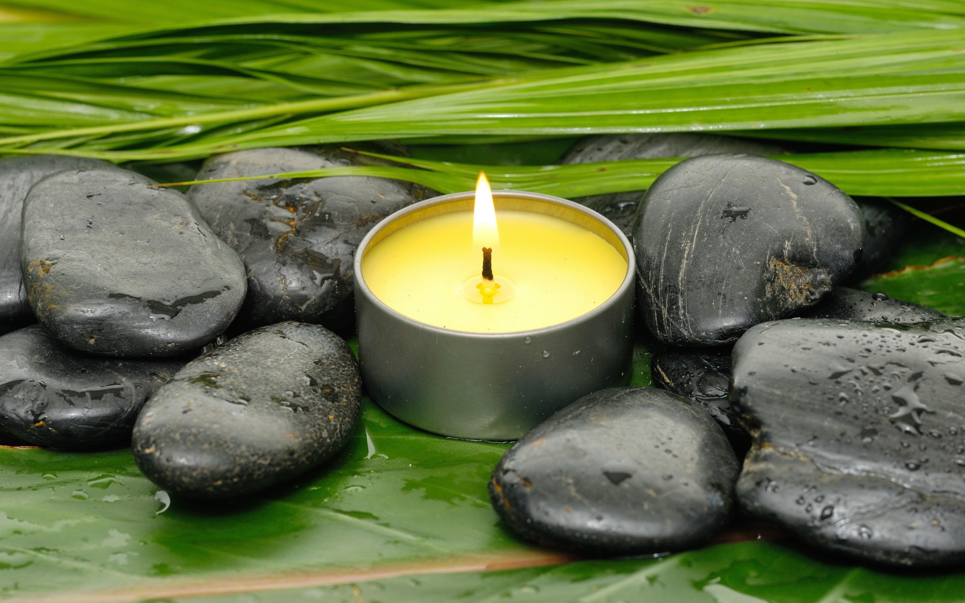 Зажженная свеча и черные камни для SPA