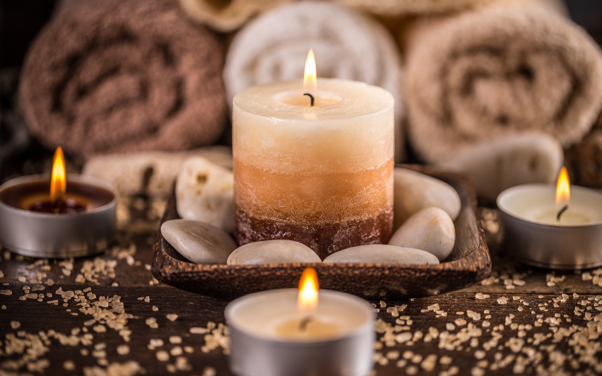 Зажженная свеча с камнями для SPA процедур