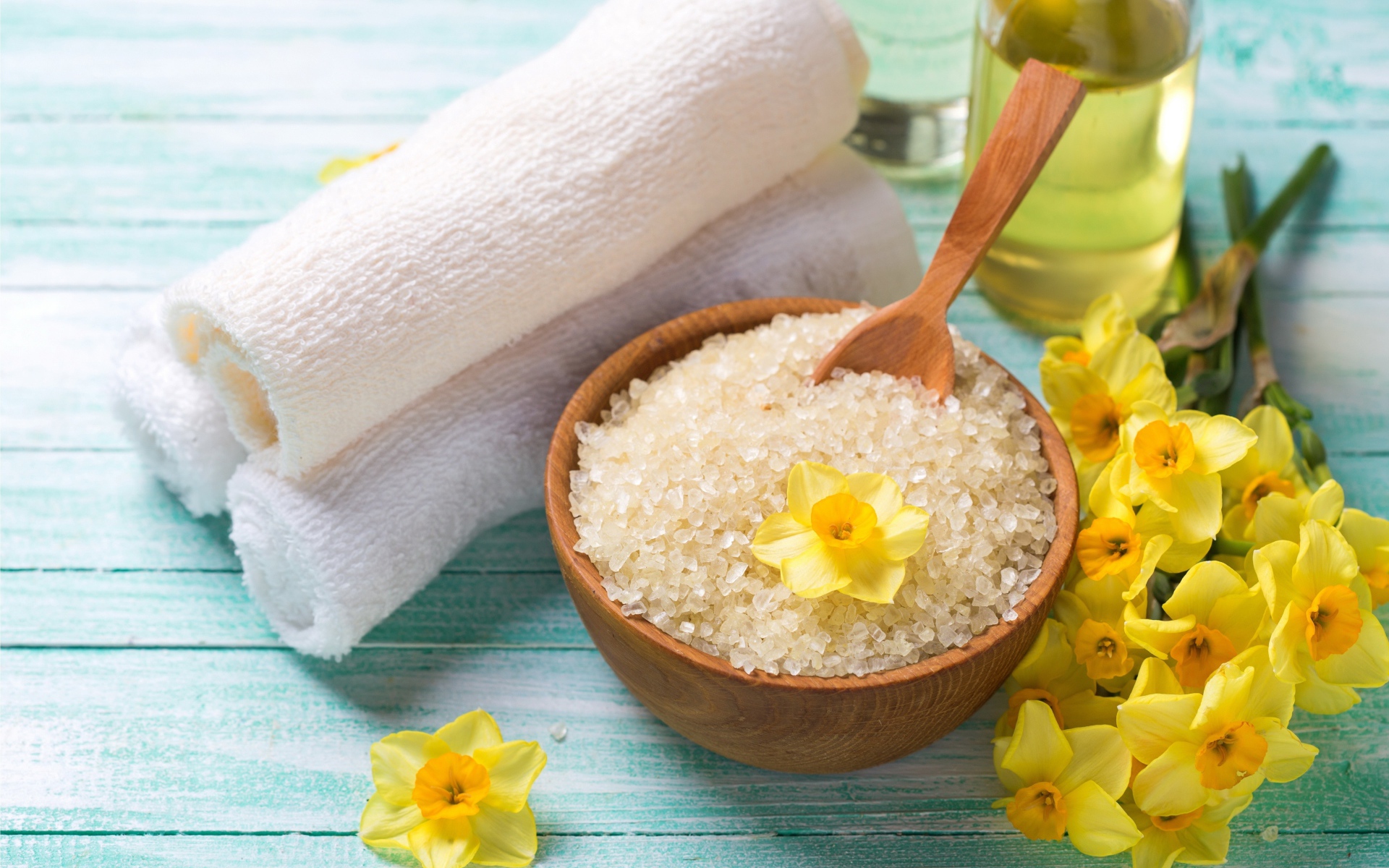 Соль с цветами нарцисса и полотенцем на столе