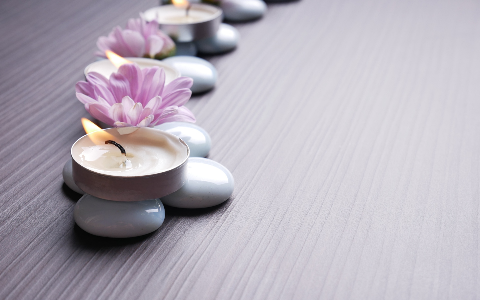 Камни с ароматическими свечами и цветами хризантемы