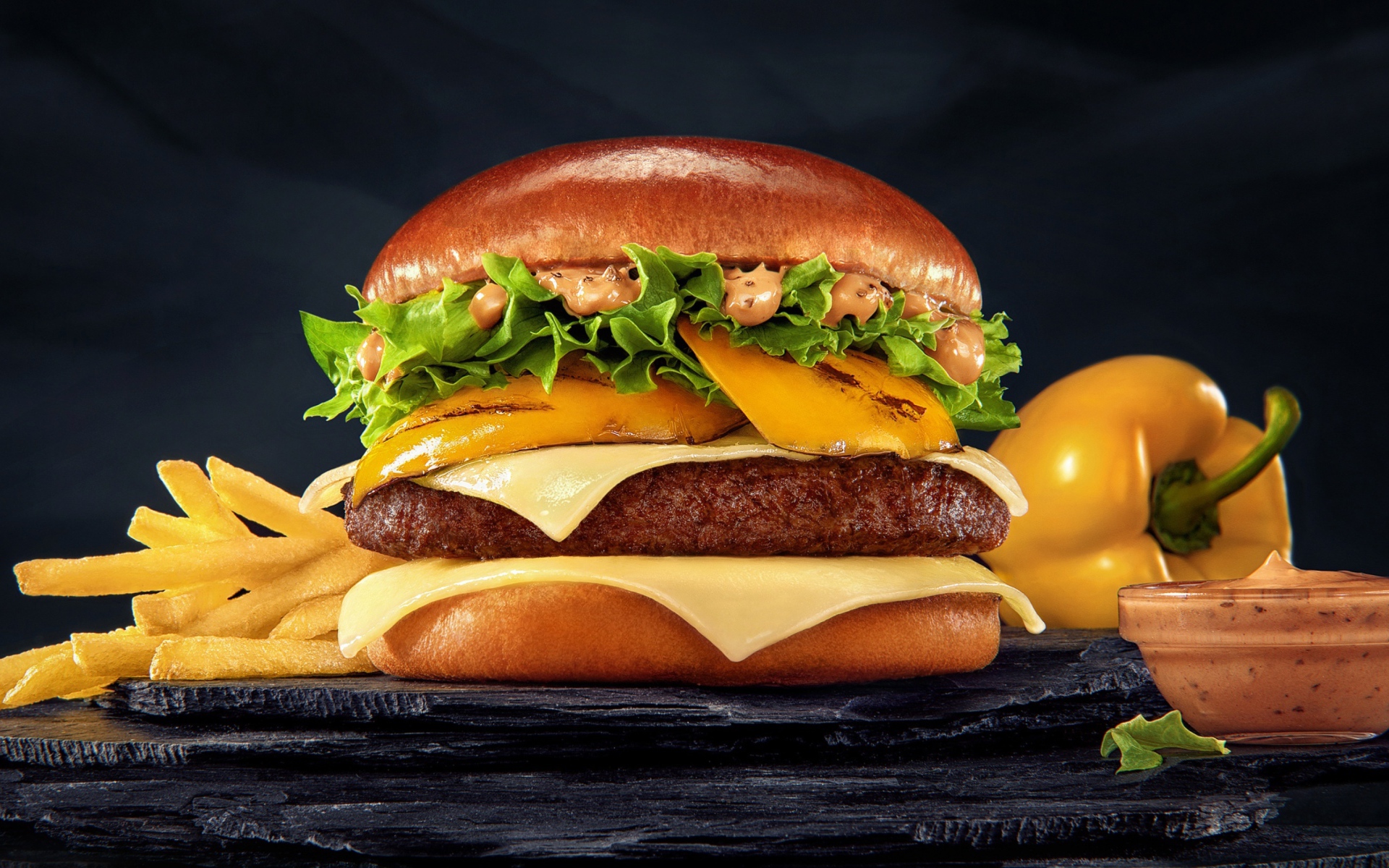 Аппетитный гамбургер с картофелем фри, болгарским перцем и соусом