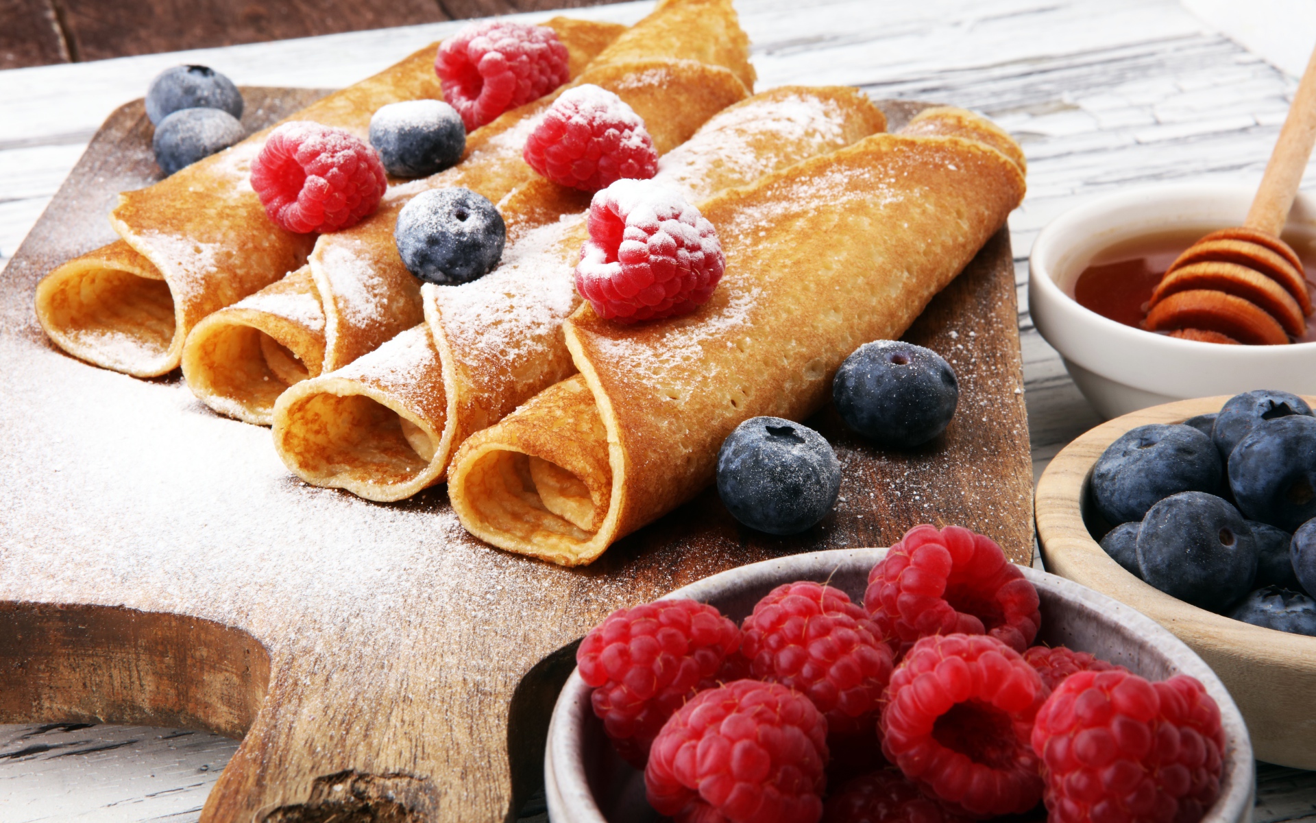 Блинчики с ягодами черники, малиной и сахарной пудрой