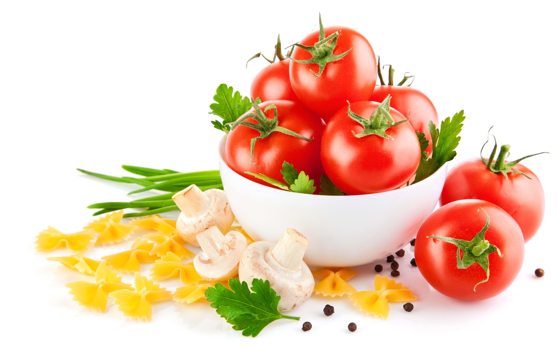 Красные помидоры, паста, лук и шампиньоны на белом фоне