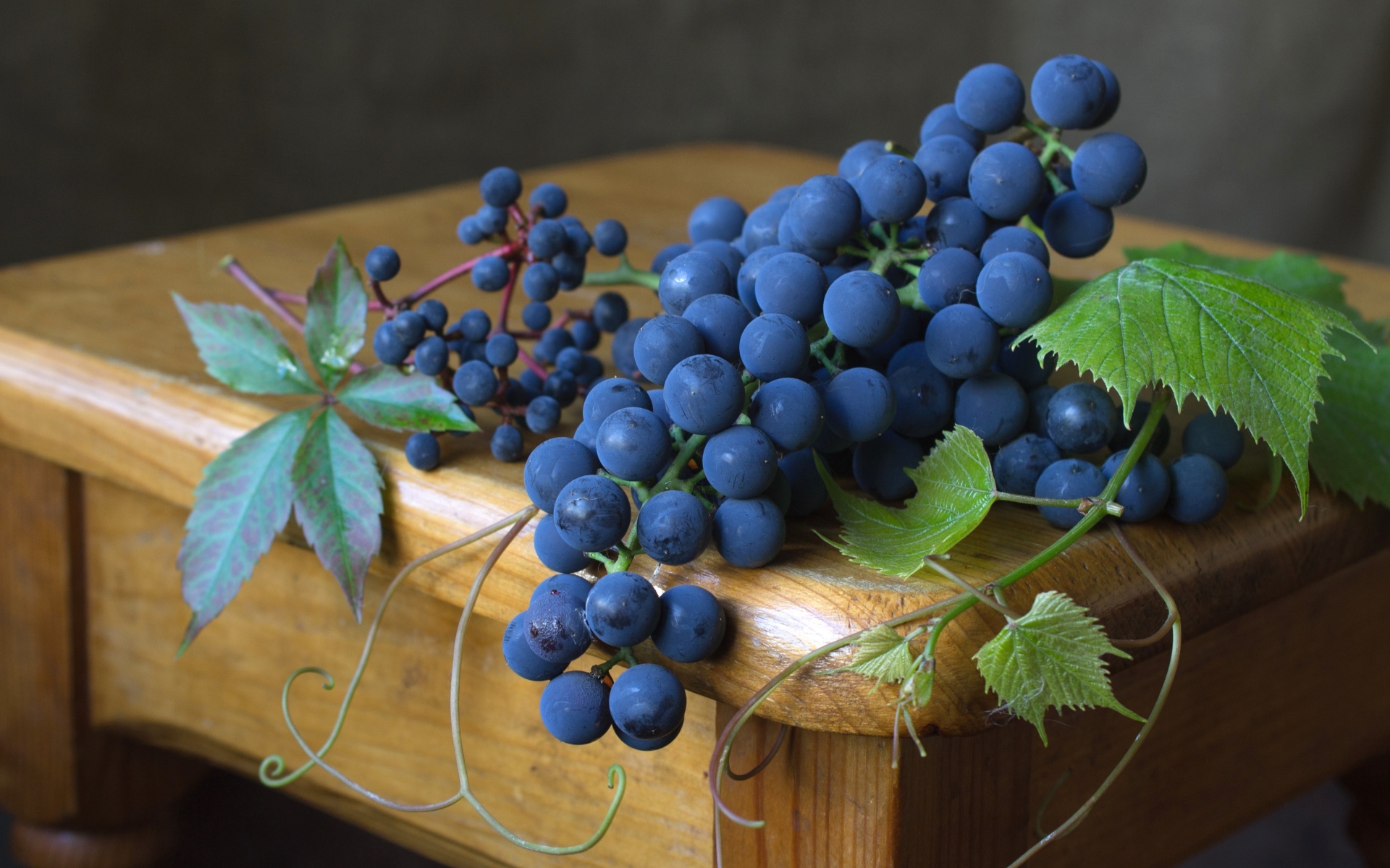 Синий виноград на деревянном столе