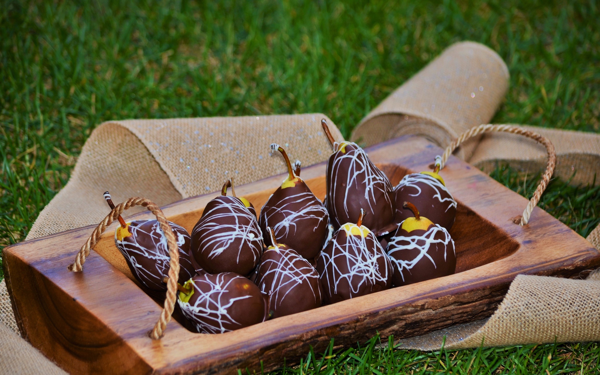 Груши в шоколадной глазури стоят на зеленой траве