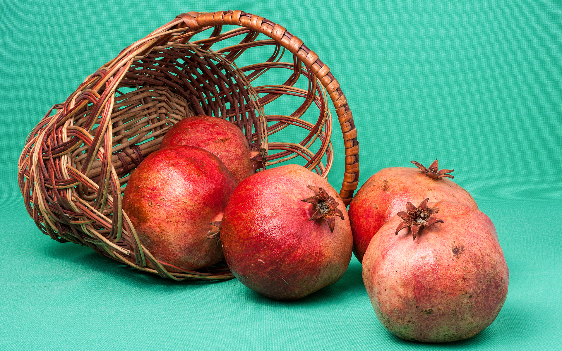 Плоды граната в корзине на голубом фоне