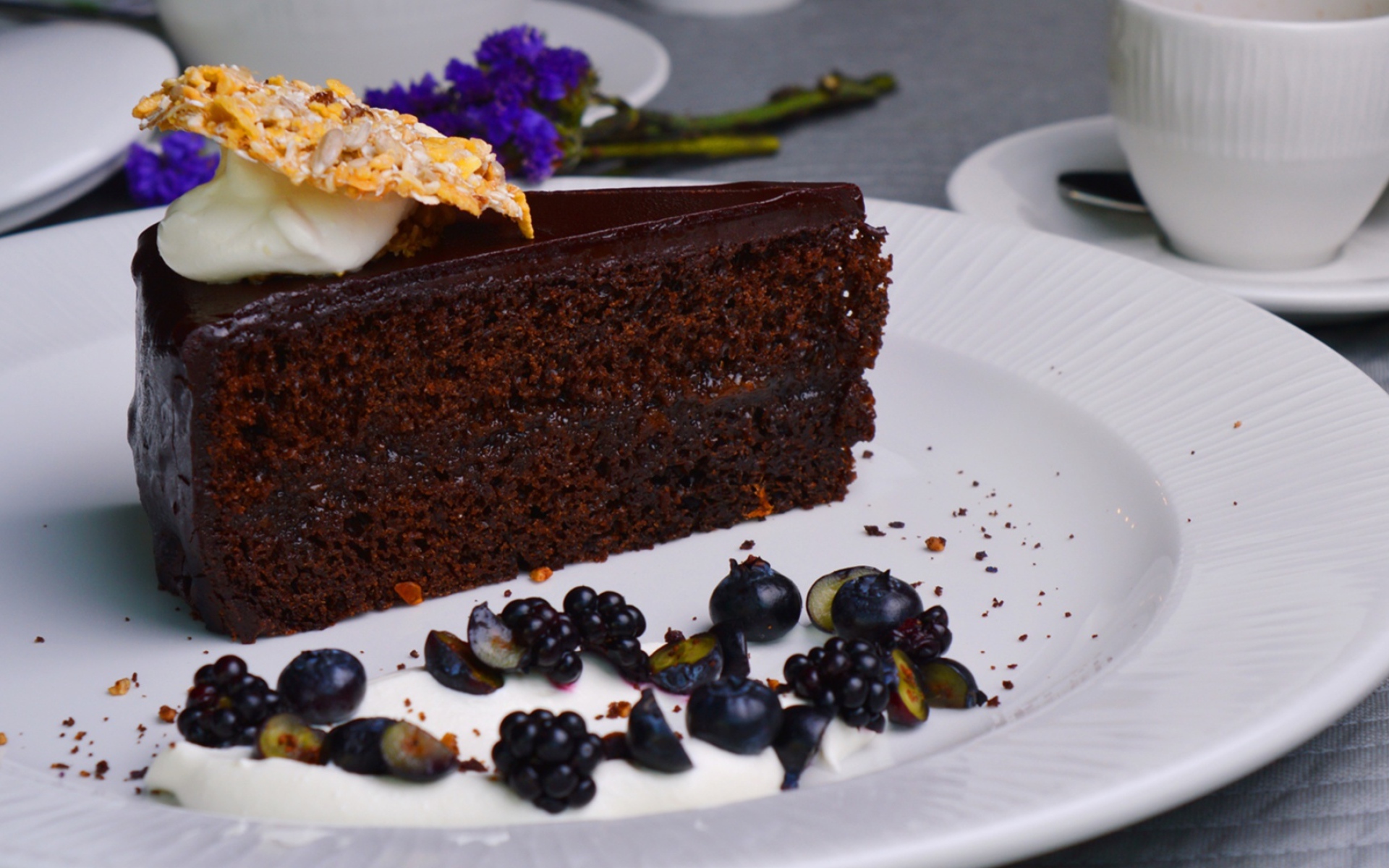 Кусок шоколадного пирога на большой белой тарелке