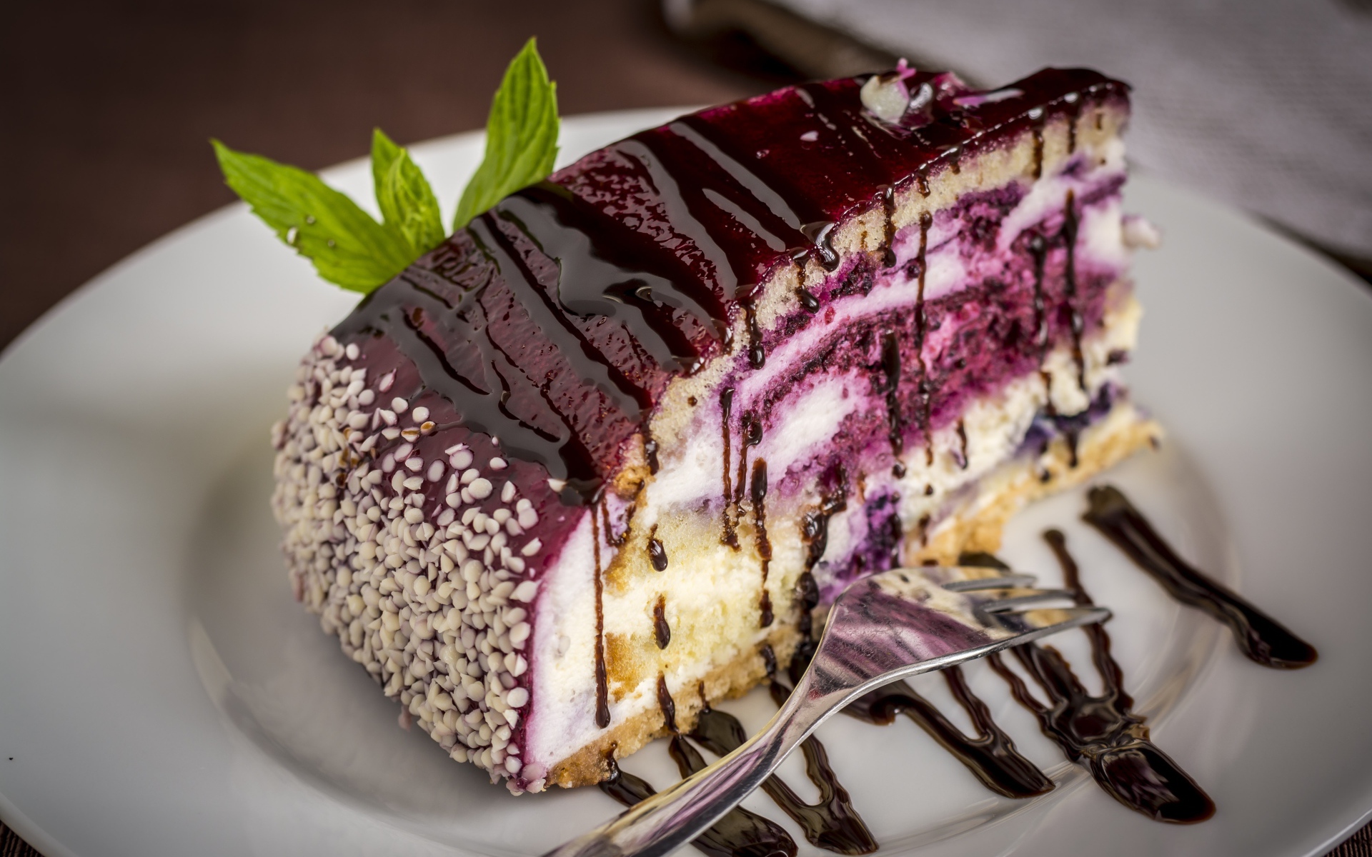 Кусок черничного пирога с джемом на белой тарелке с вилкой