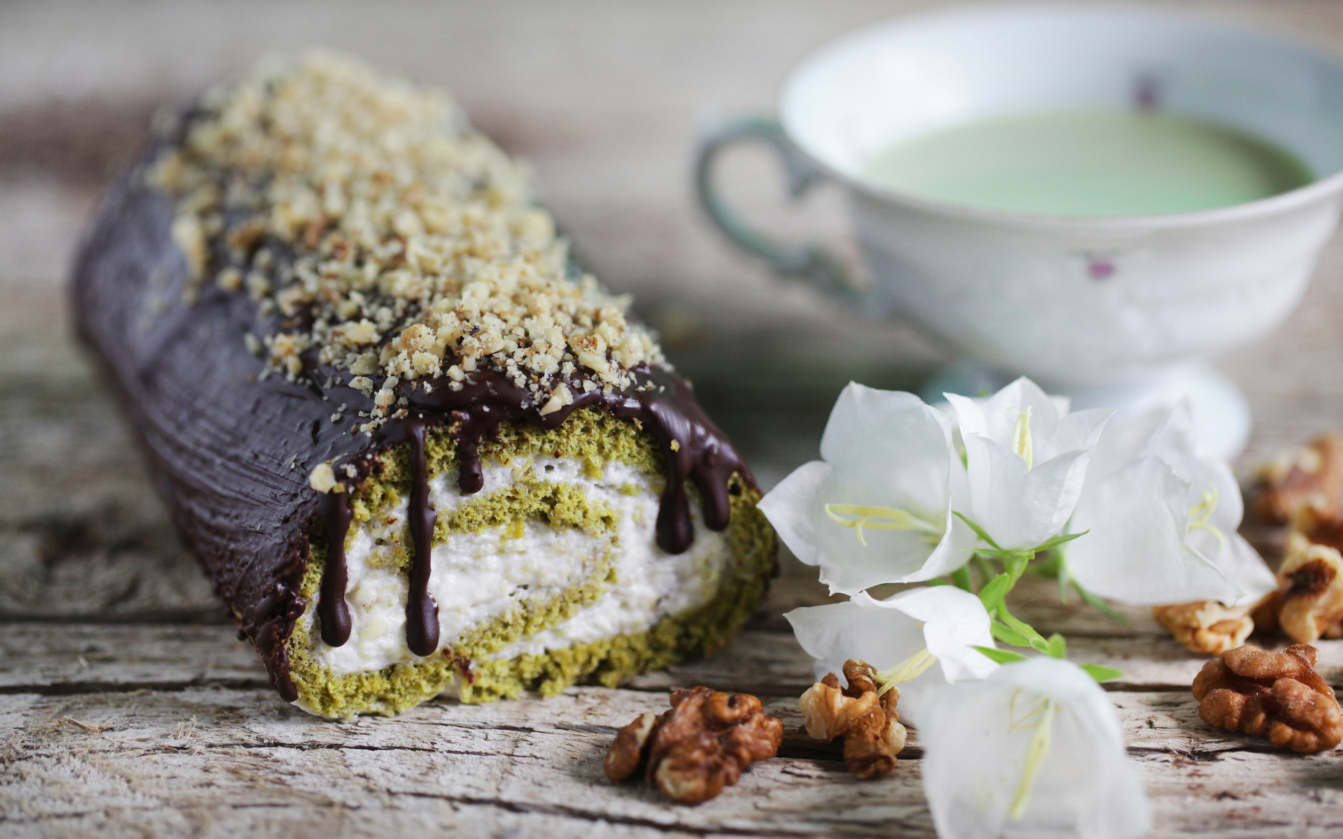 Аппетитный сладкий рулет с шоколадом на столе с белыми цветами колокольчика