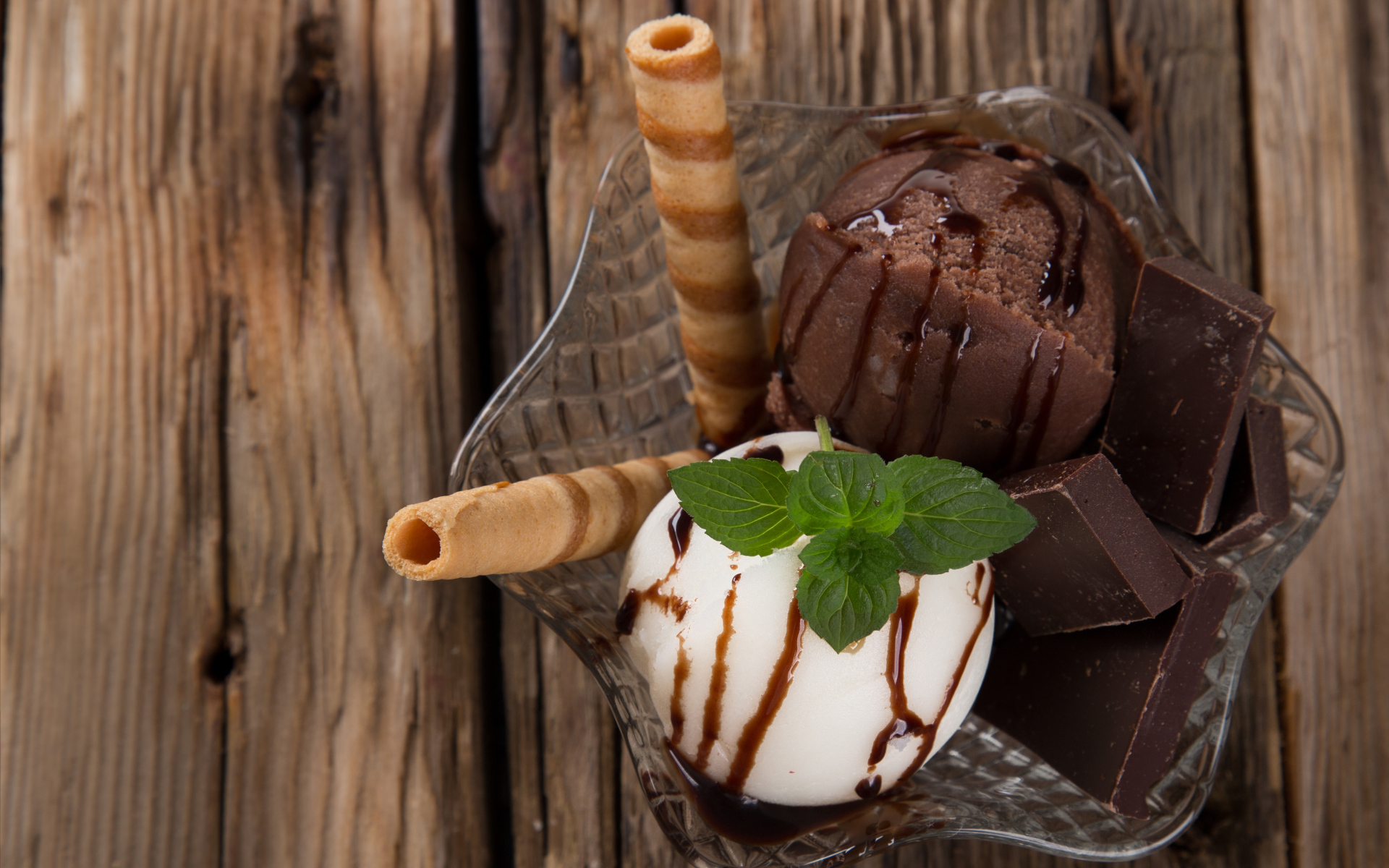 Шарик сливочного и шоколадного мороженого в пиале с трубочками