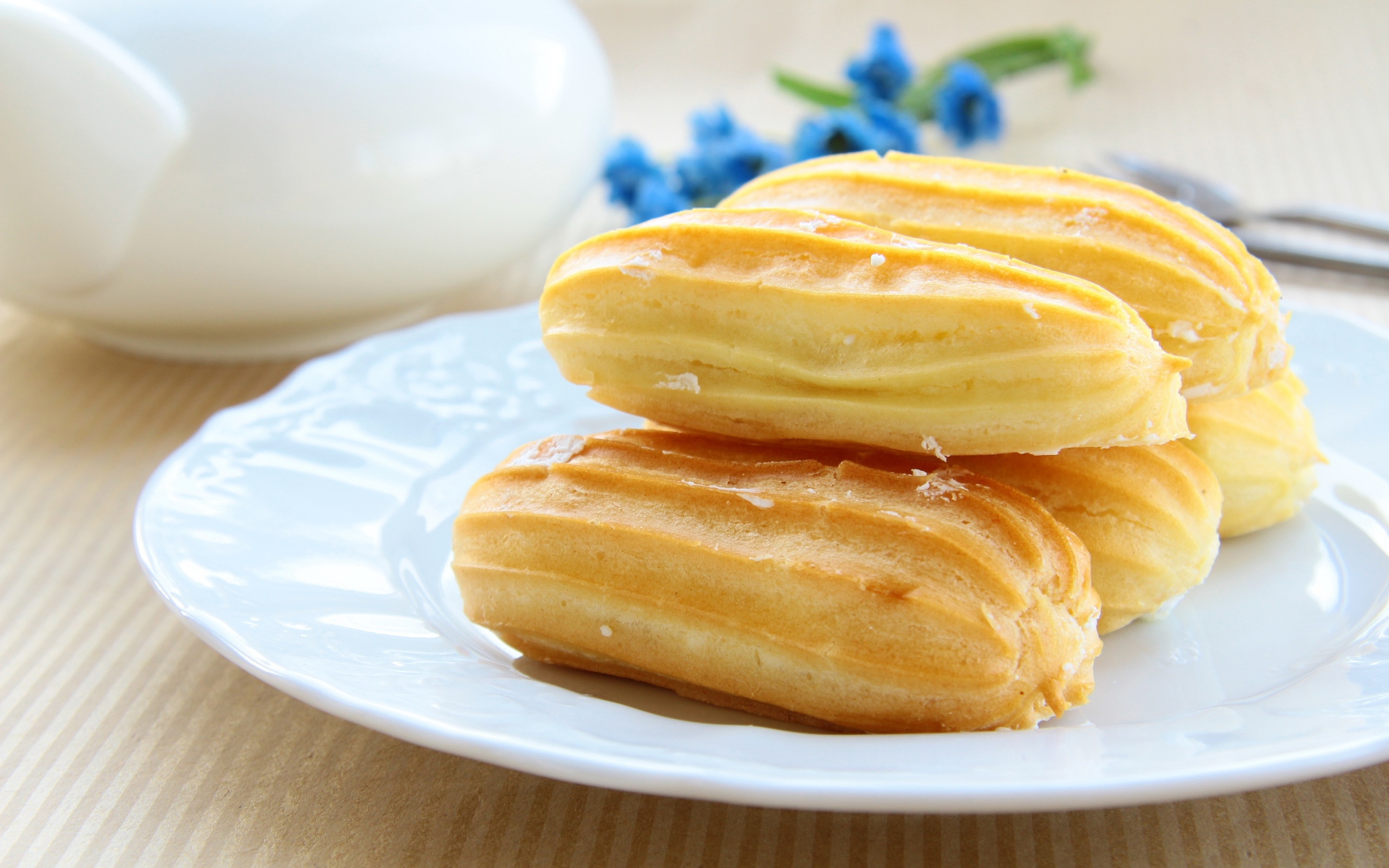 Заварные пирожные на большой белой тарелке 