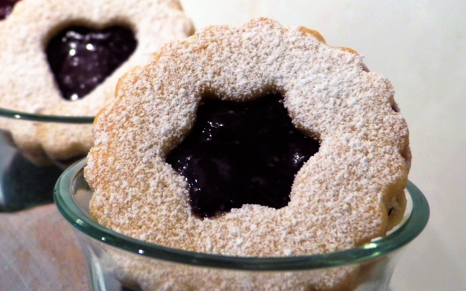 Фигурные печенья с джемом посыпанные сахарной пудрой 