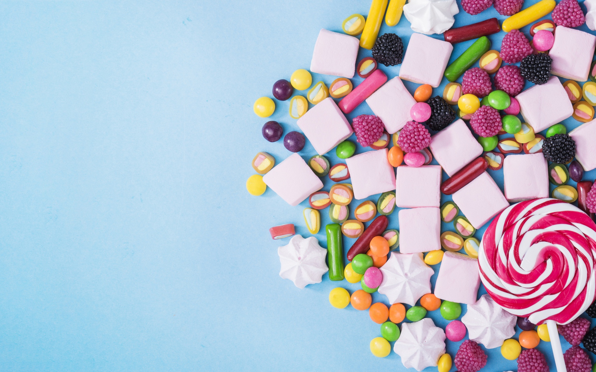 Маршмеллоу, конфеты и желе на голубом фоне