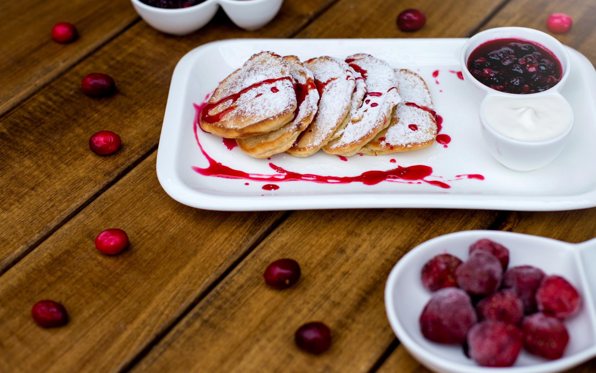 Оладьи с сахарной пудрой и вареньем на белой тарелке