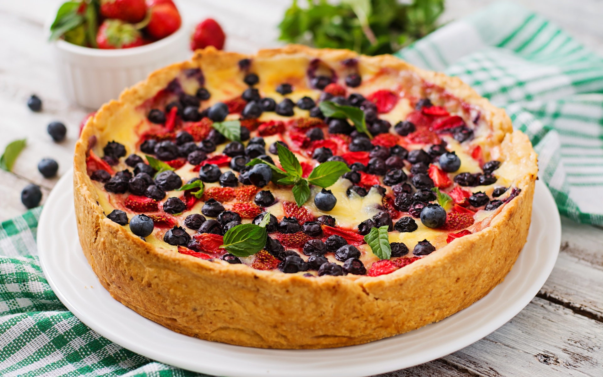 Сладкий пирог с черникой и клубникой на белом блюде