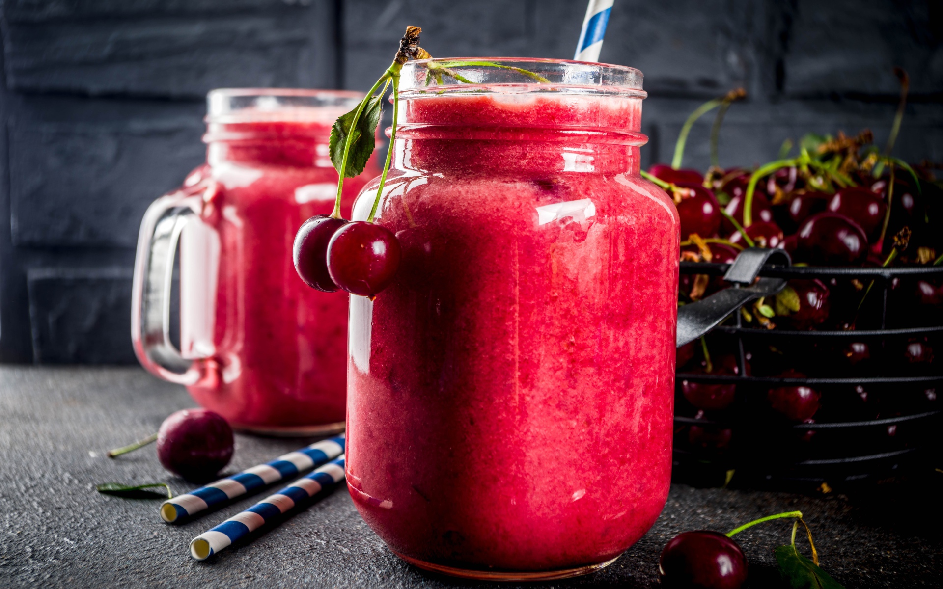 Вишневое смузи в стеклянной банке на столе с ягодами