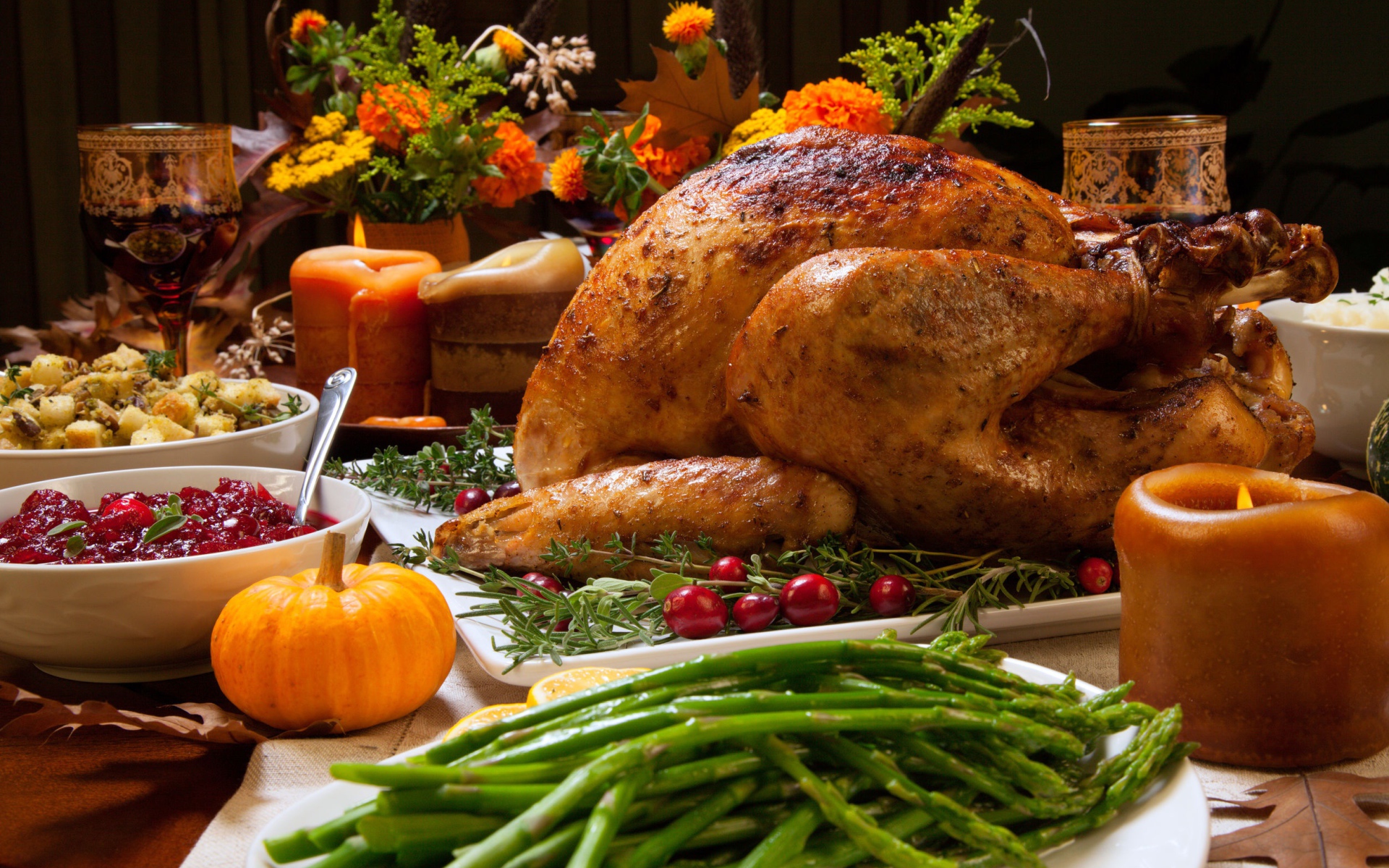 Аппетитная запеченная курица с зеленой спаржей и угощениями на праздничном столе