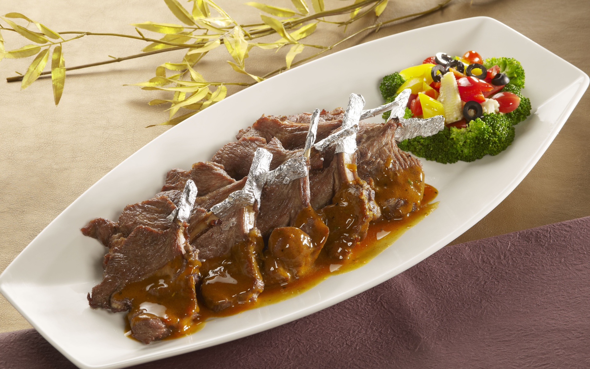 Мясо на белой тарелке с соусом и овощами 