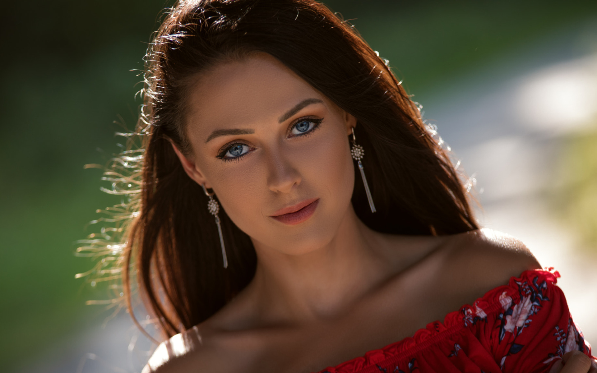 Красивая голубоглазая брюнетка с серьгами у ушах