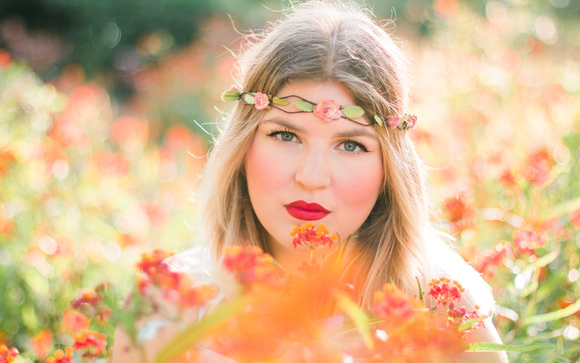 Красивая голубоглазая девушка в красных цветах