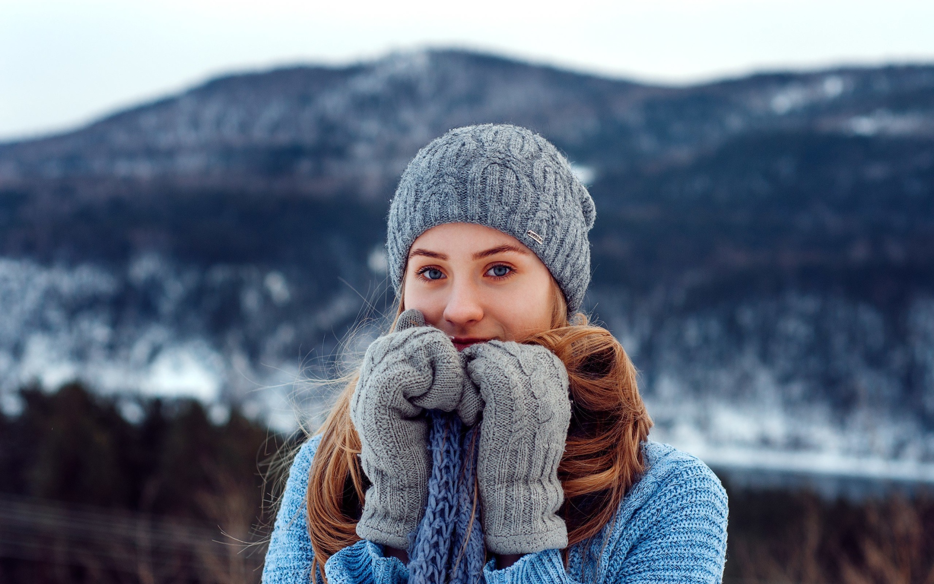 Красивая девушка в теплой шапке и варежках