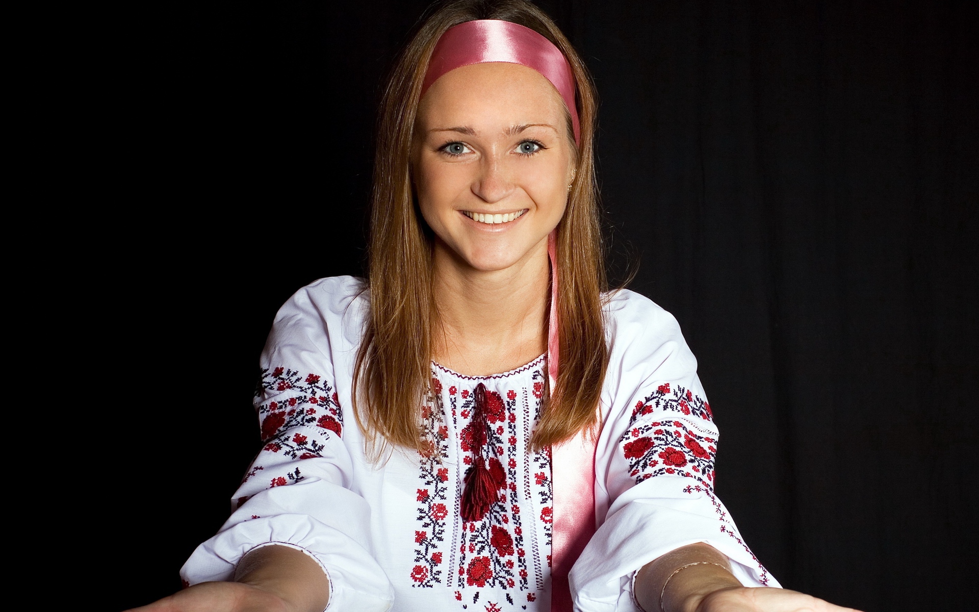 Красивая девушка в вышитой рубашке на черном фоне