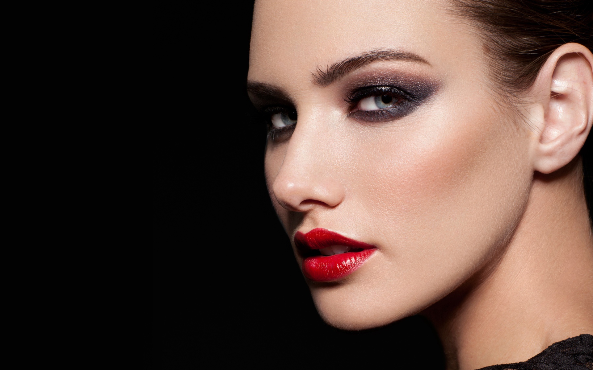 Красивая девушка с яркой помадой на губах на черном фоне