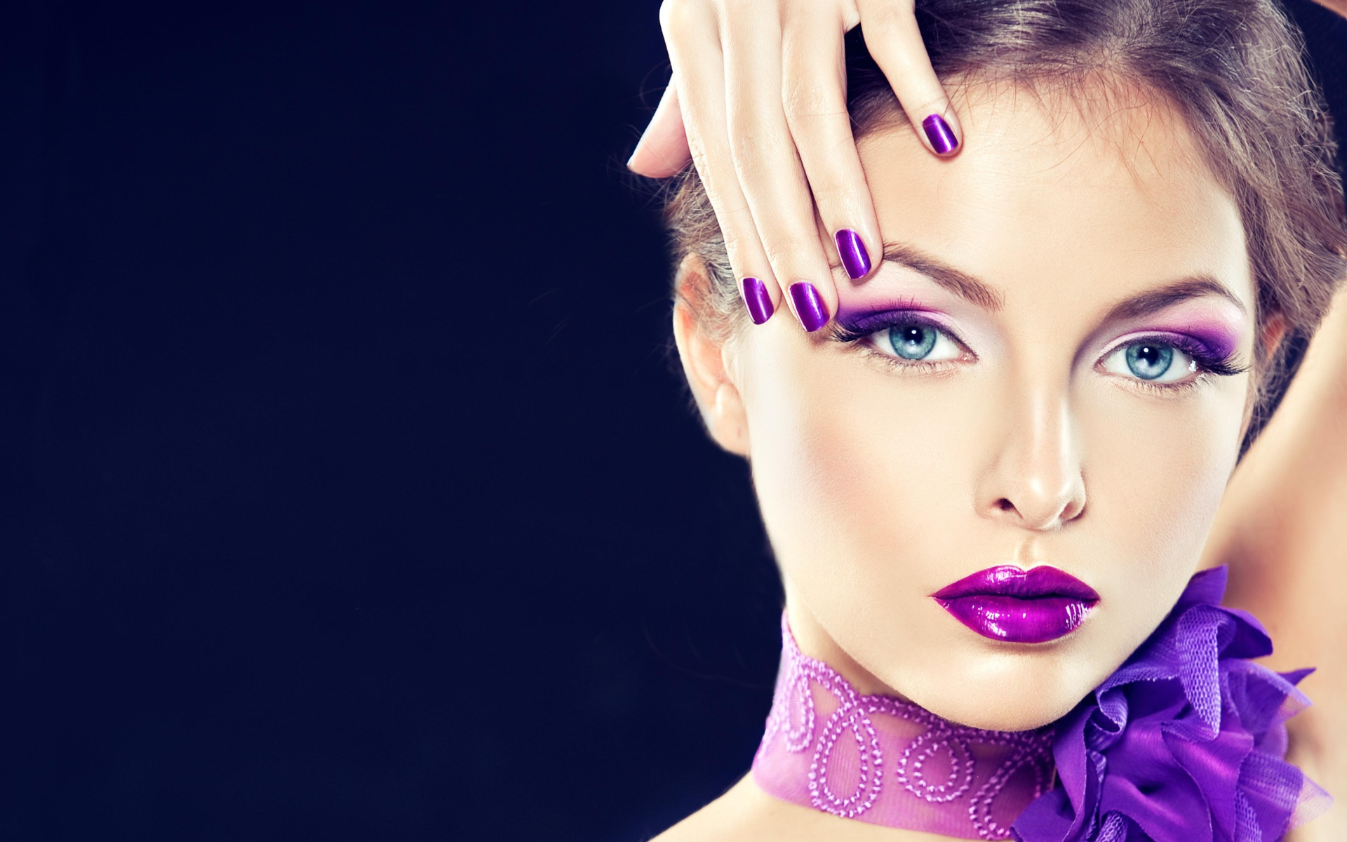 Красивая девушка с ярким фиолетовым макияжем с рукой у лица