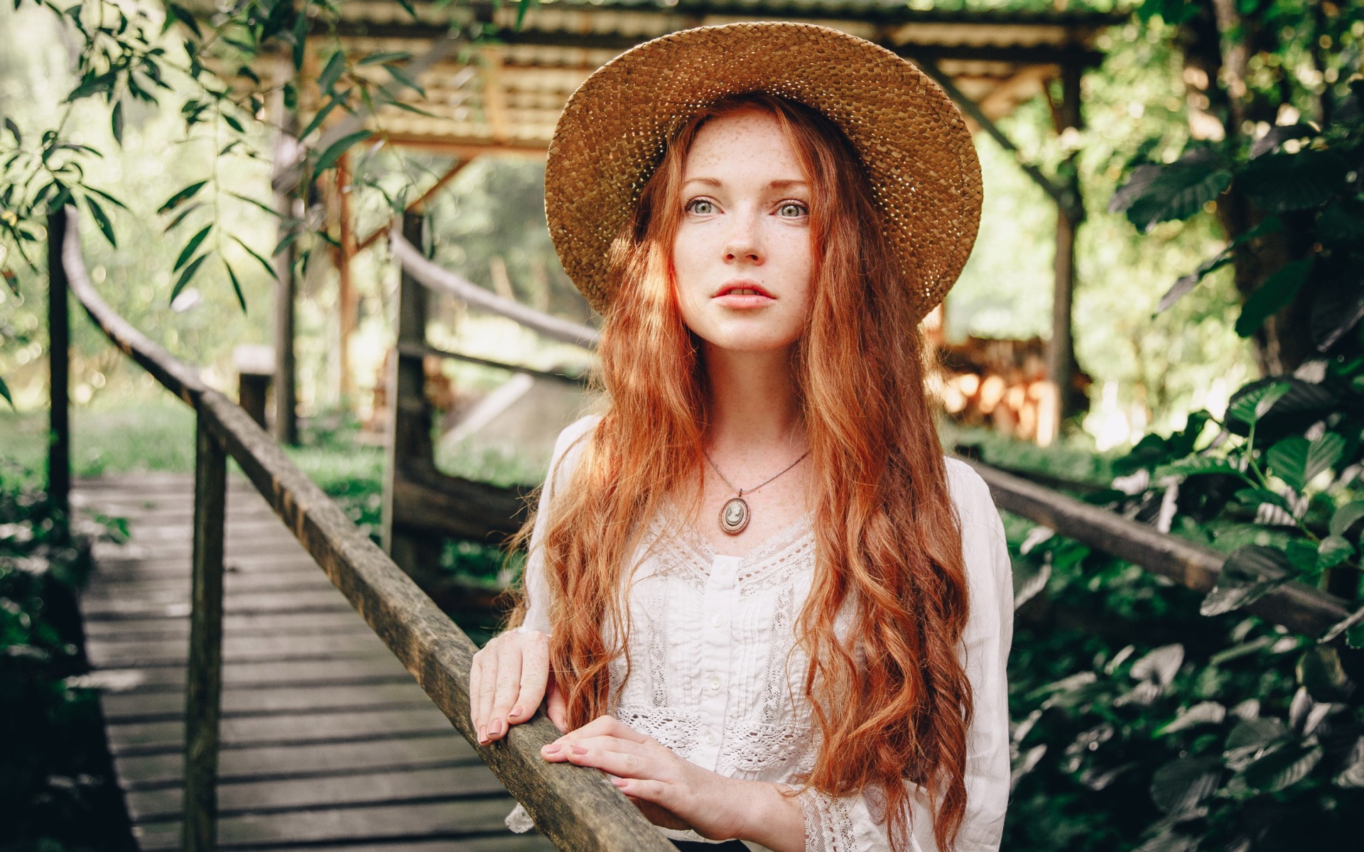 Красивая рыжеволосая девушка в соломенной шляпе
