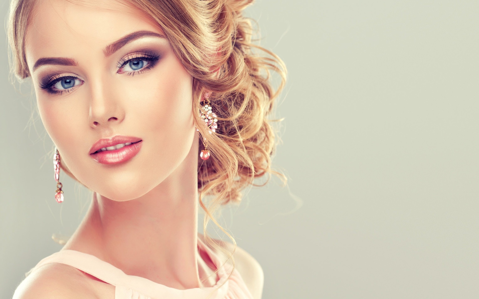 Красивая стильная голубоглазая девушка с красивым макияжем и прической