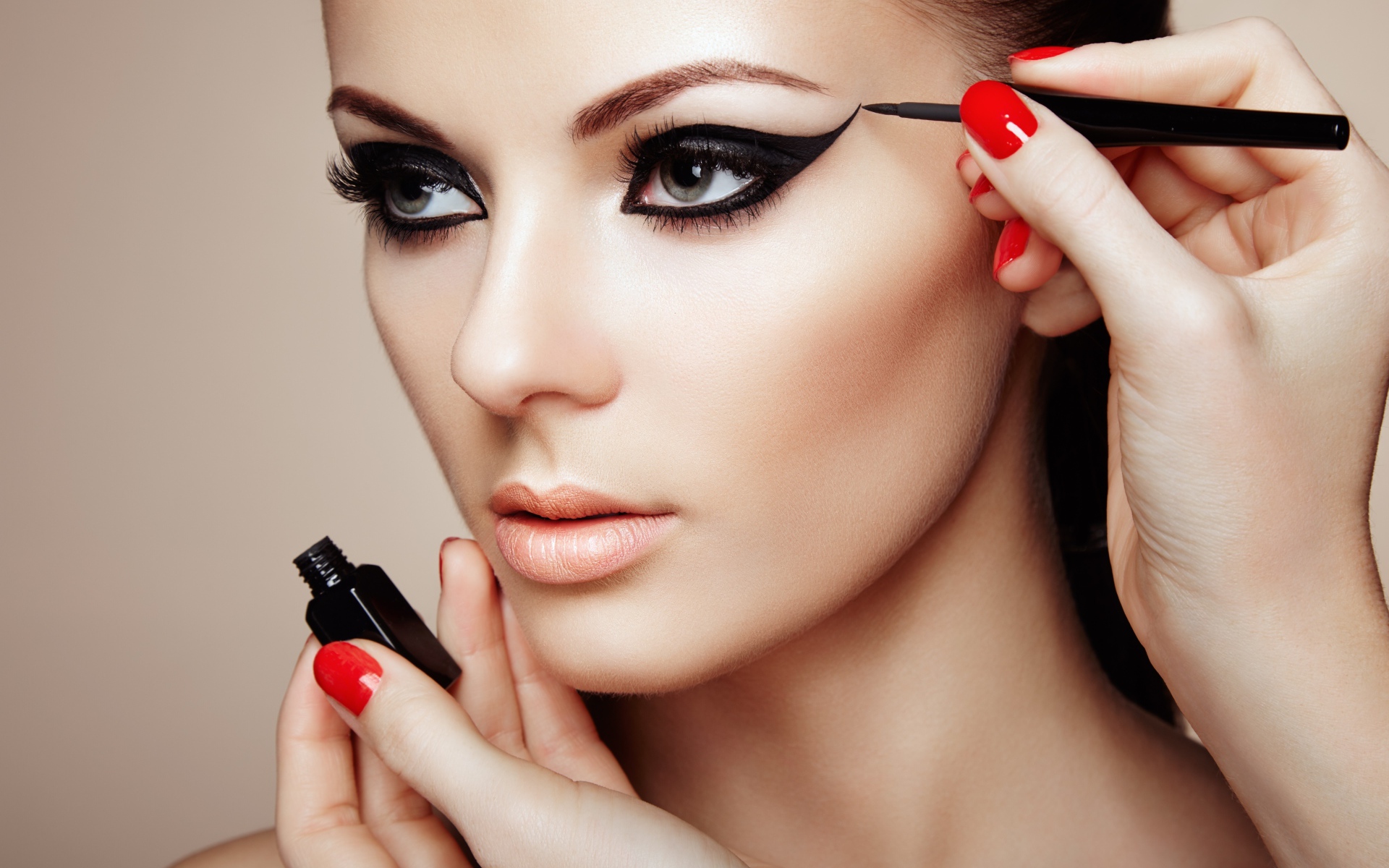 Красивой молодой девушке модели делают макияж глаз