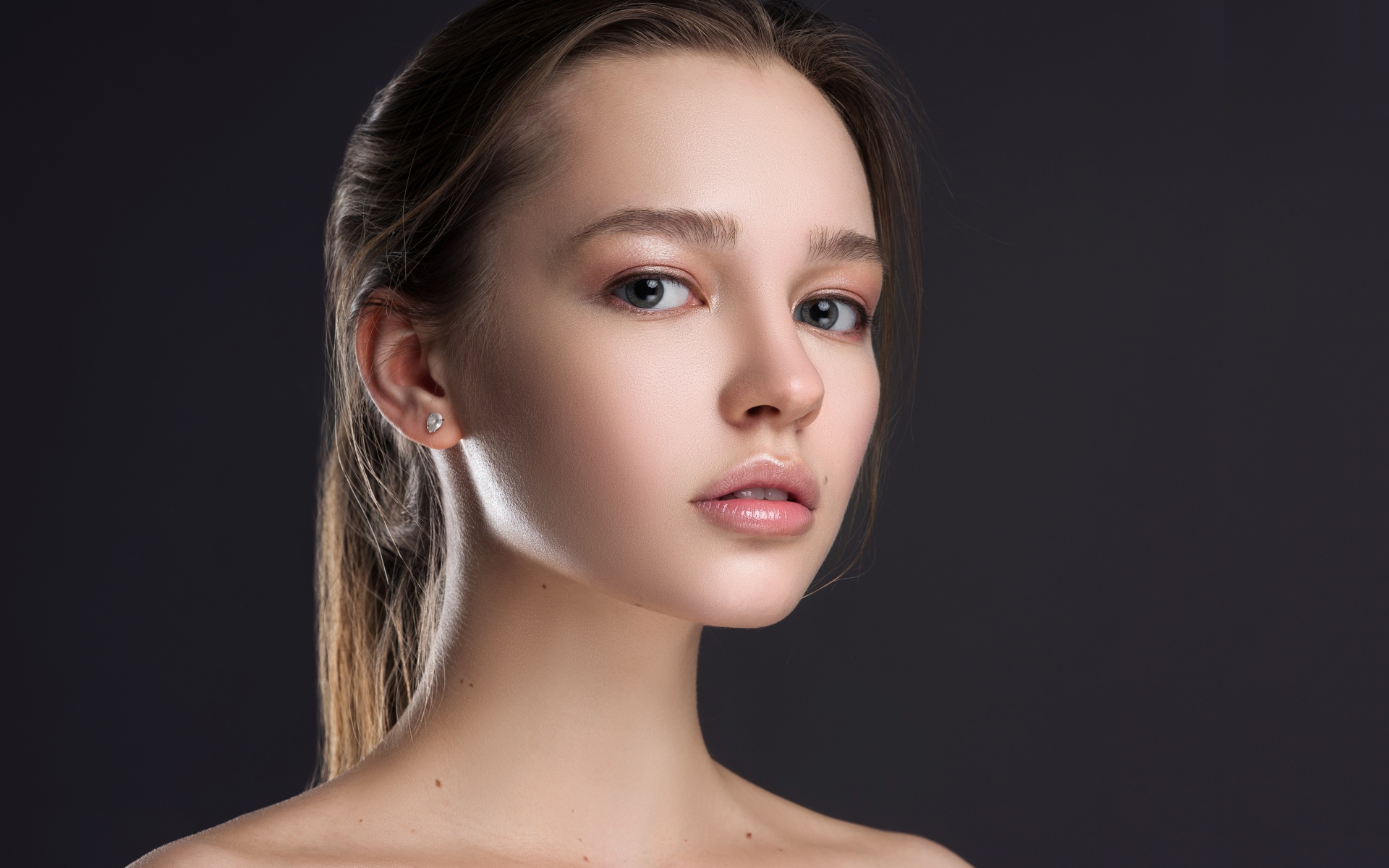 Нежная настоящая девушка шатенка на сером фоне