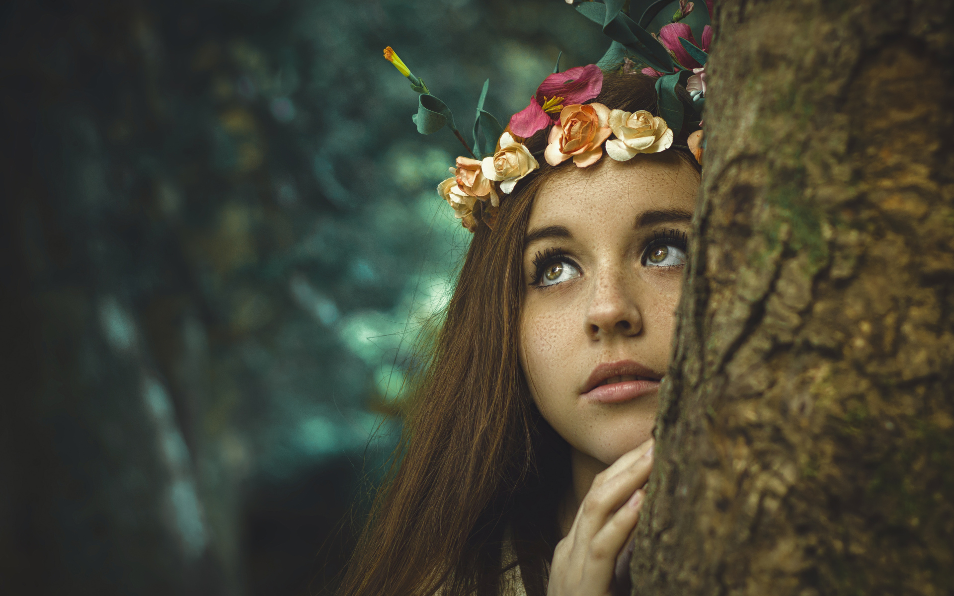 Девушка с венком на голове у дерева 