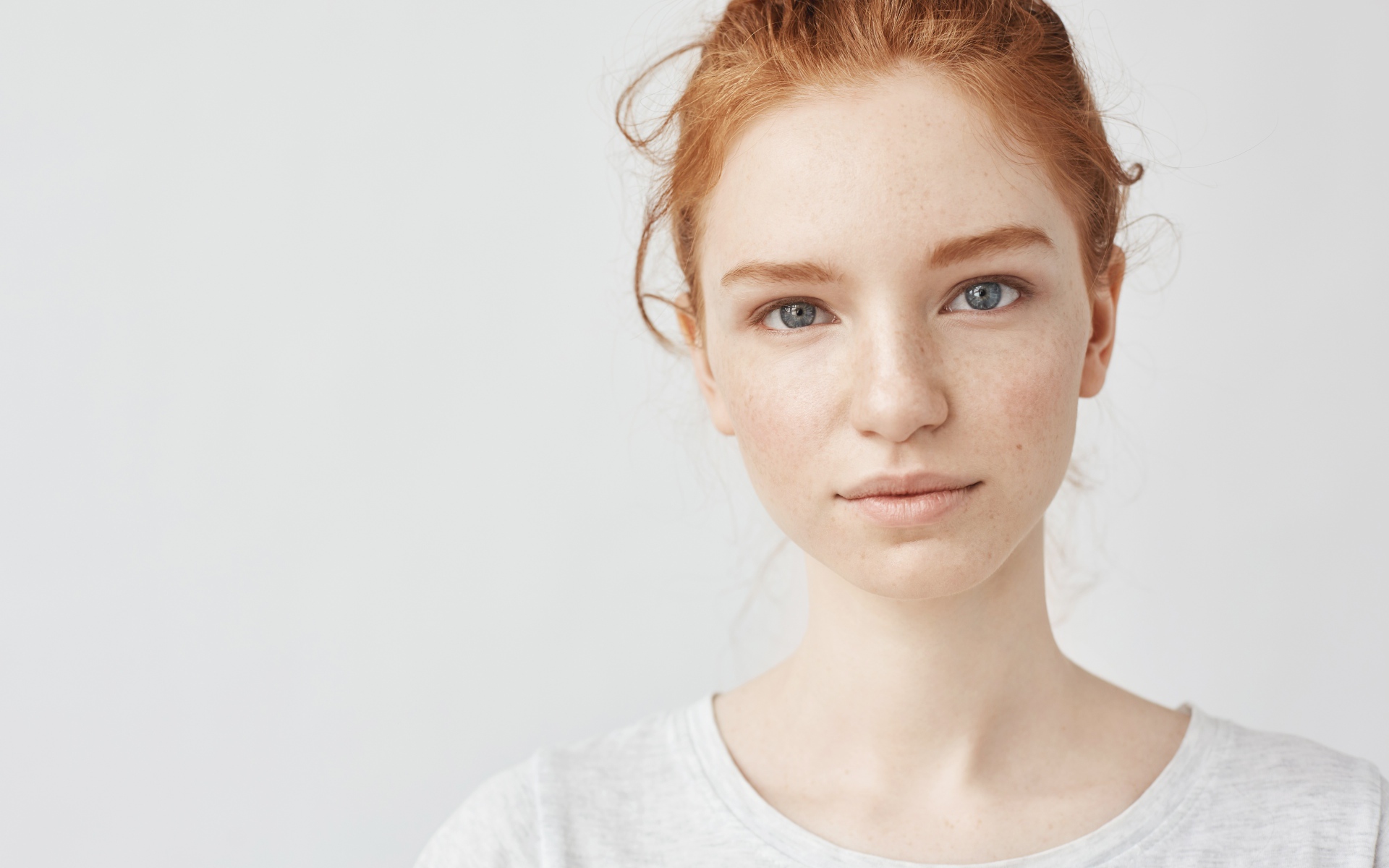 Рыжеволосая девушка на сером фоне