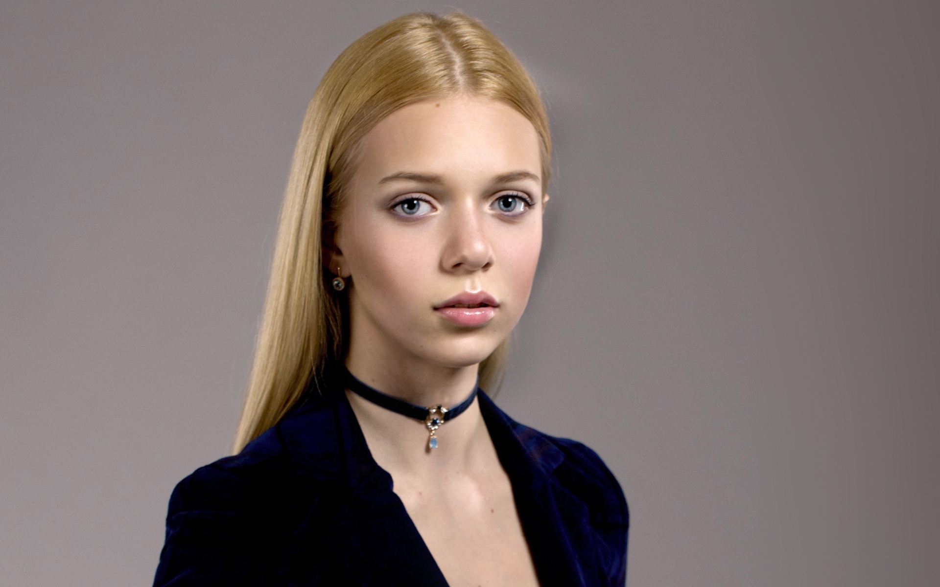 Нежная голубоглазая девушка с украшением на шее 