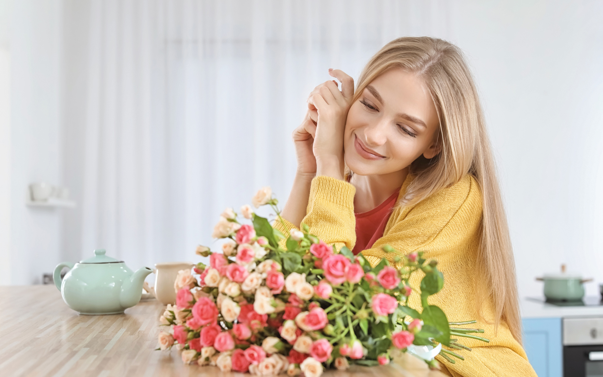 Молодая блондинка с букетом роз на столе