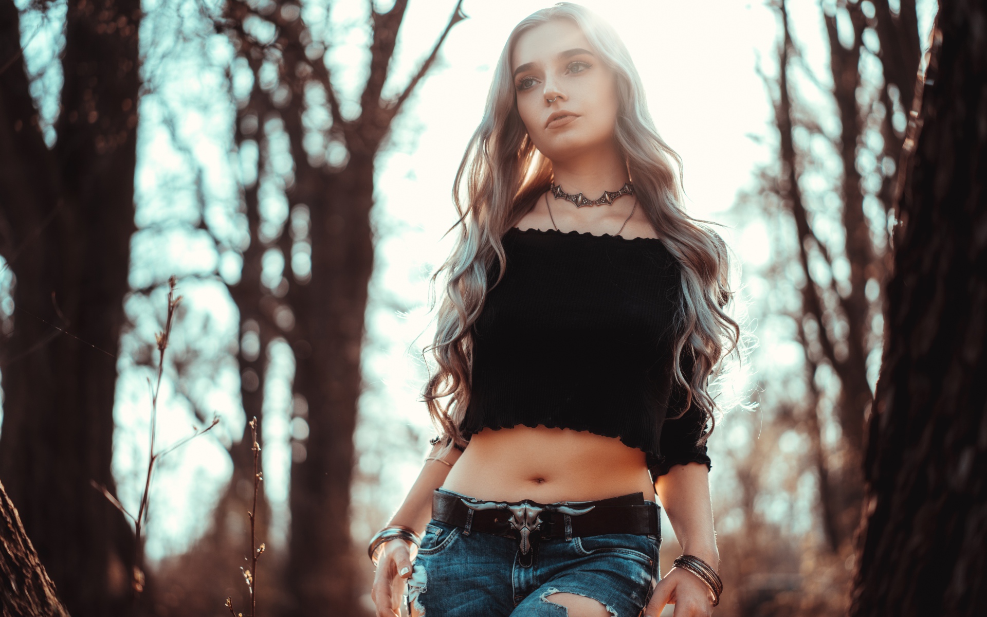 Молодая девушка в рваных джинсах с пирсингом в носу