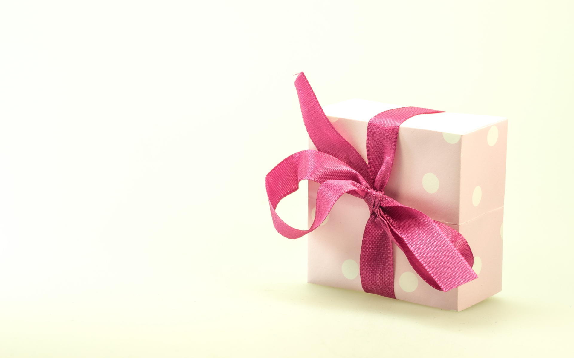 Gift box with pink bow on white background