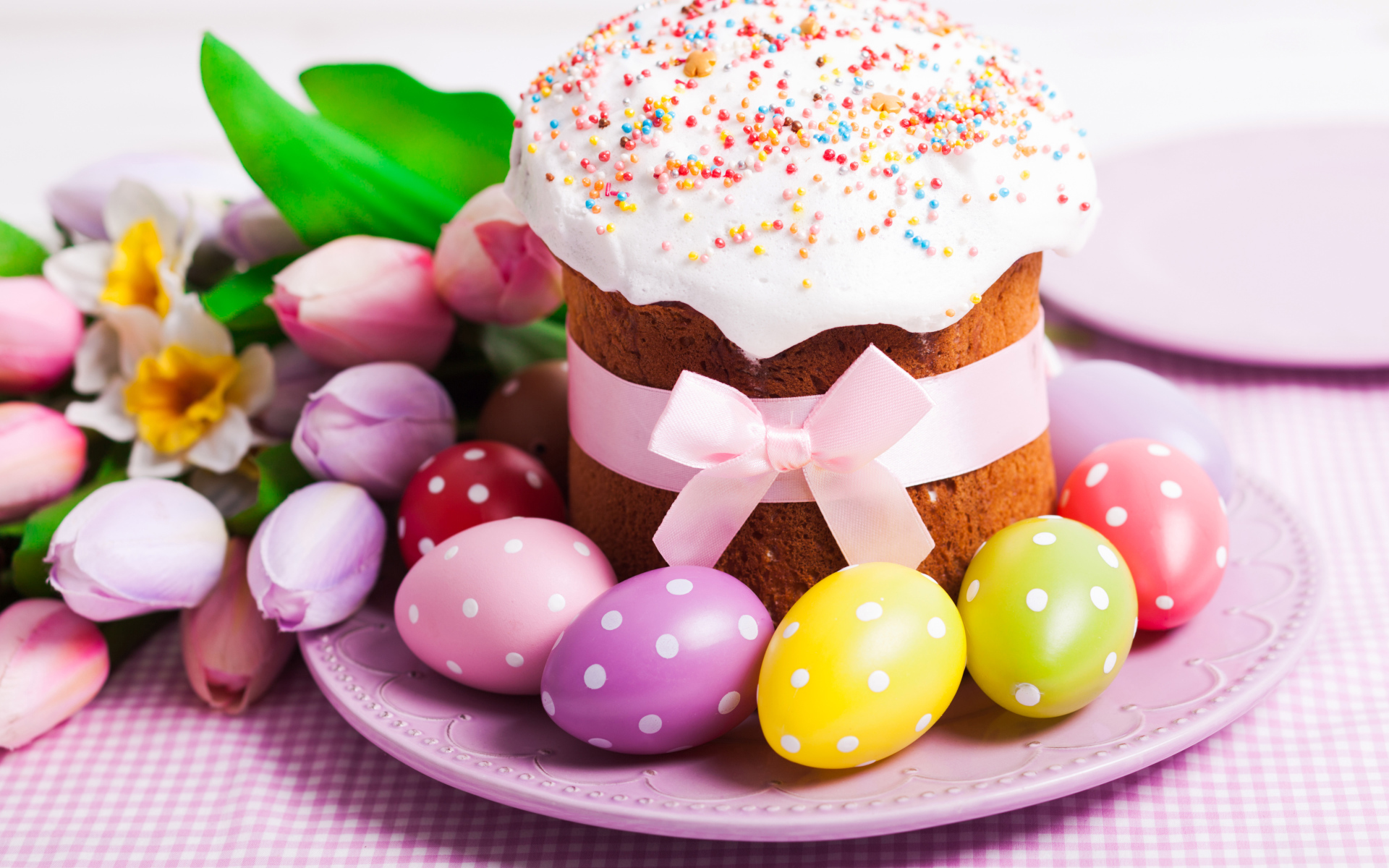 Пасхальный кулич с крашеными яйцами и букетом цветов