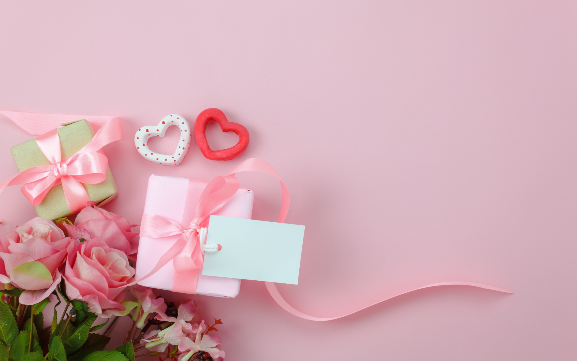 A bouquet of roses, gifts and two hearts on a pink background greeting card template for March 8